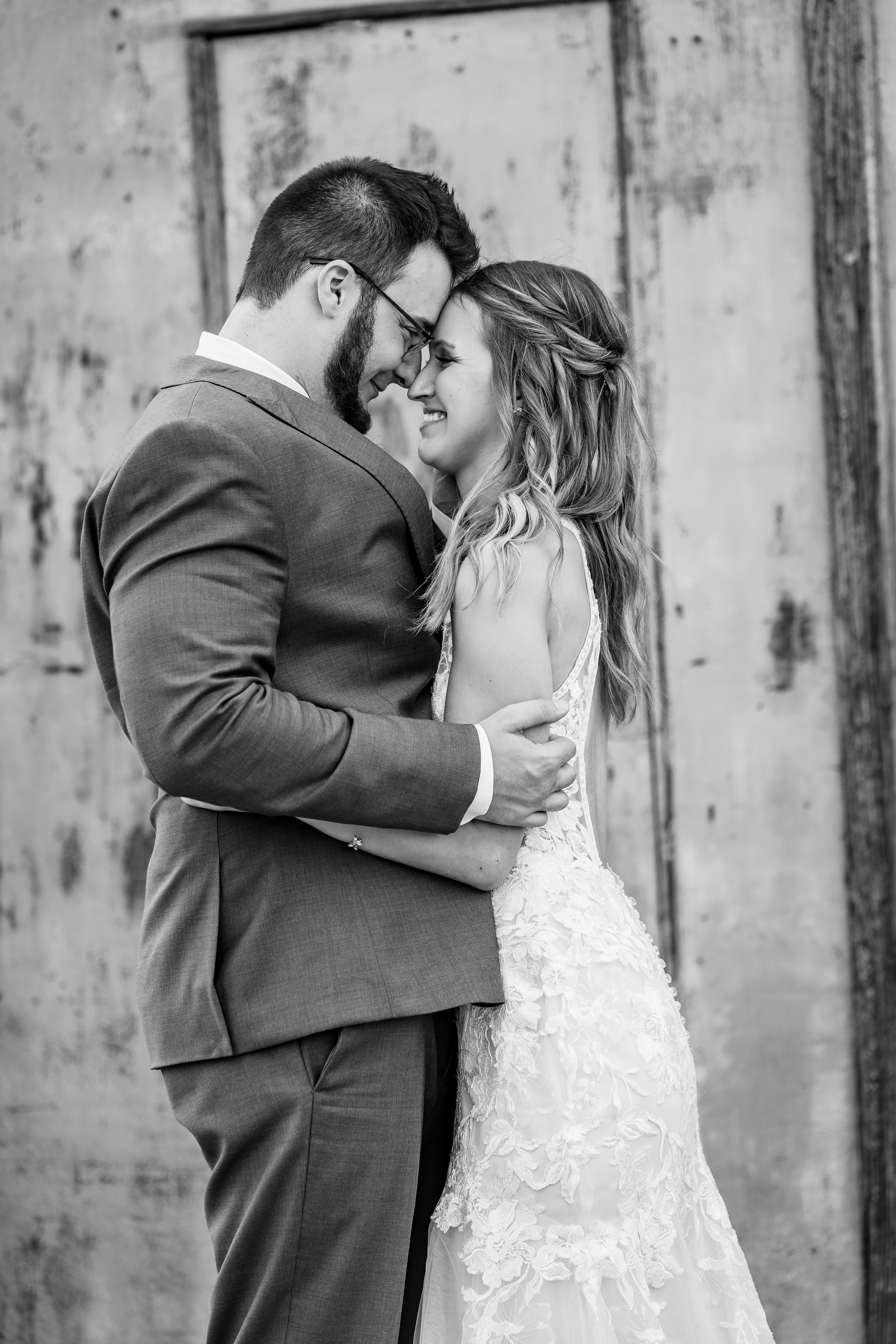 black and white portrait of bride and groom embracing