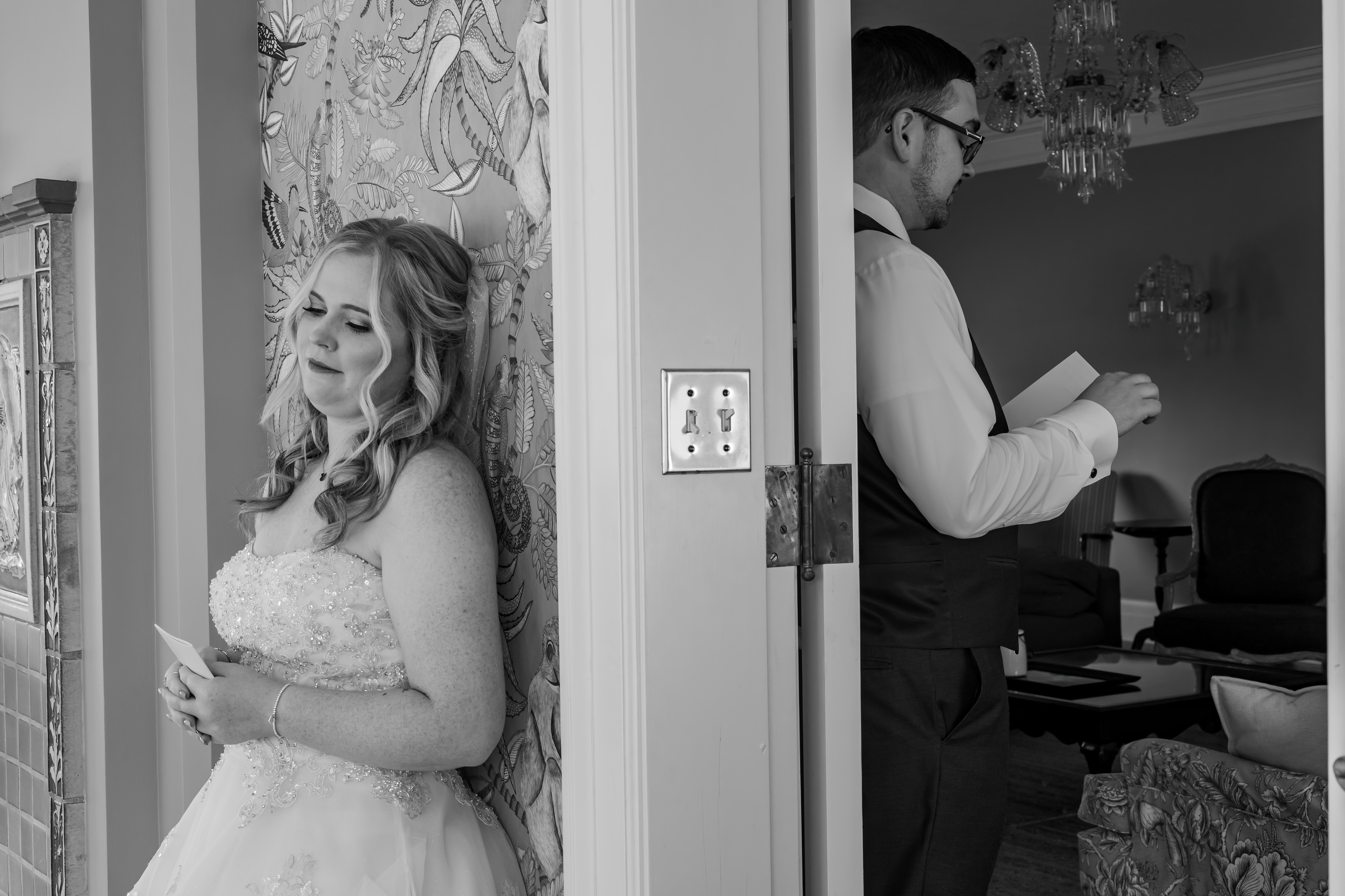 black and white portrait of bride and groom reading letters to each other