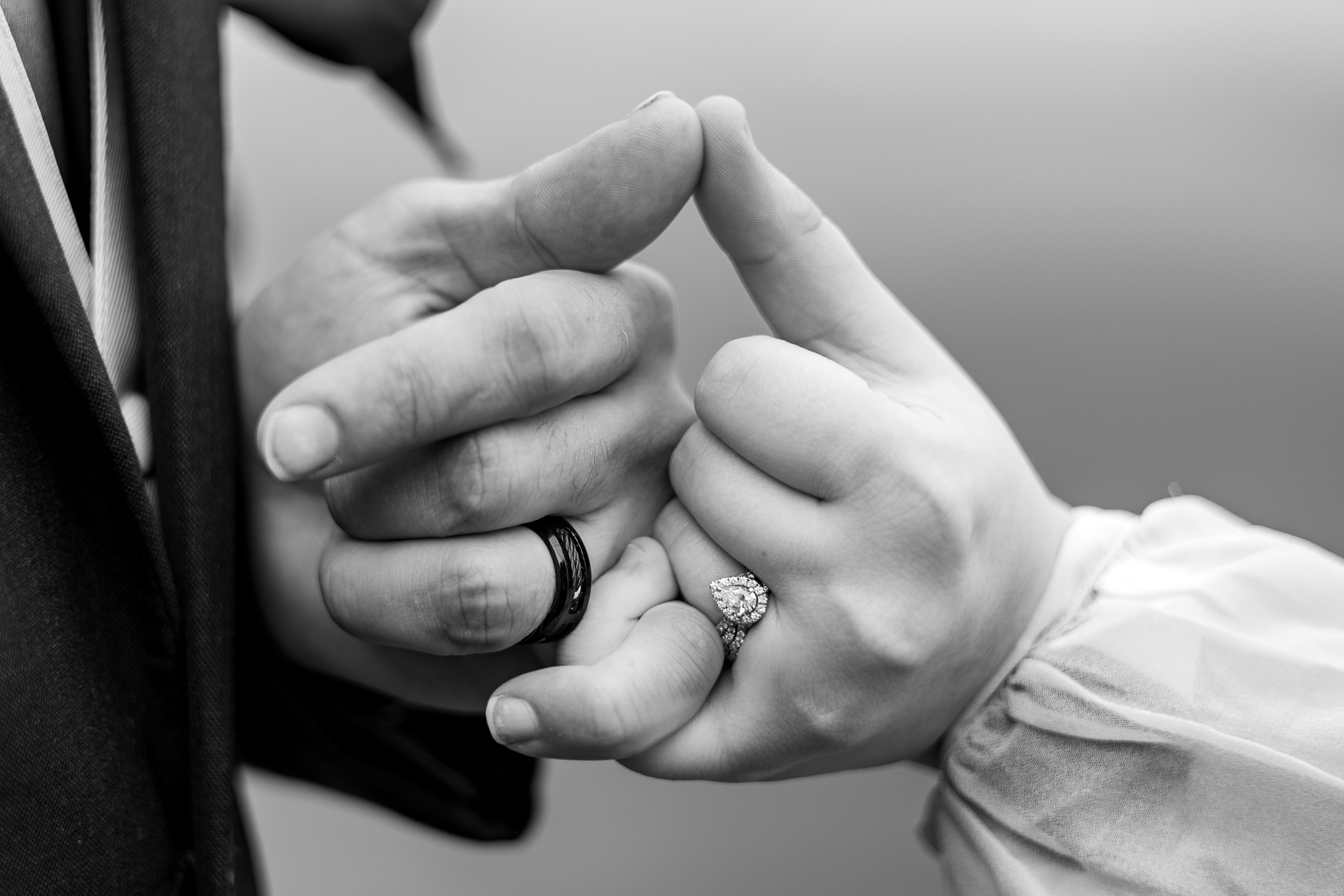 black and white portrait of bride and groom making pinky promise