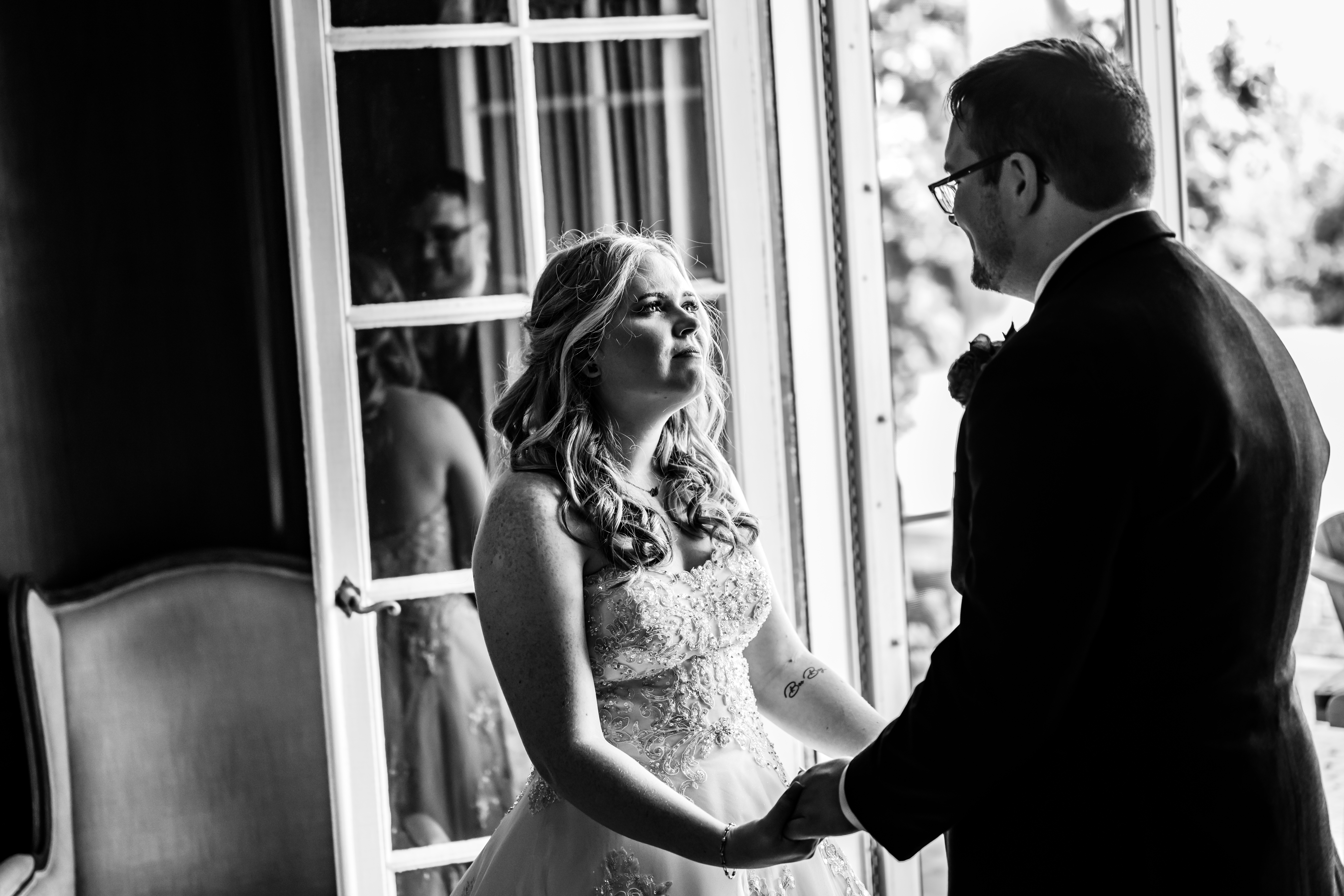 black and white portrait of bride and groom holding hands
