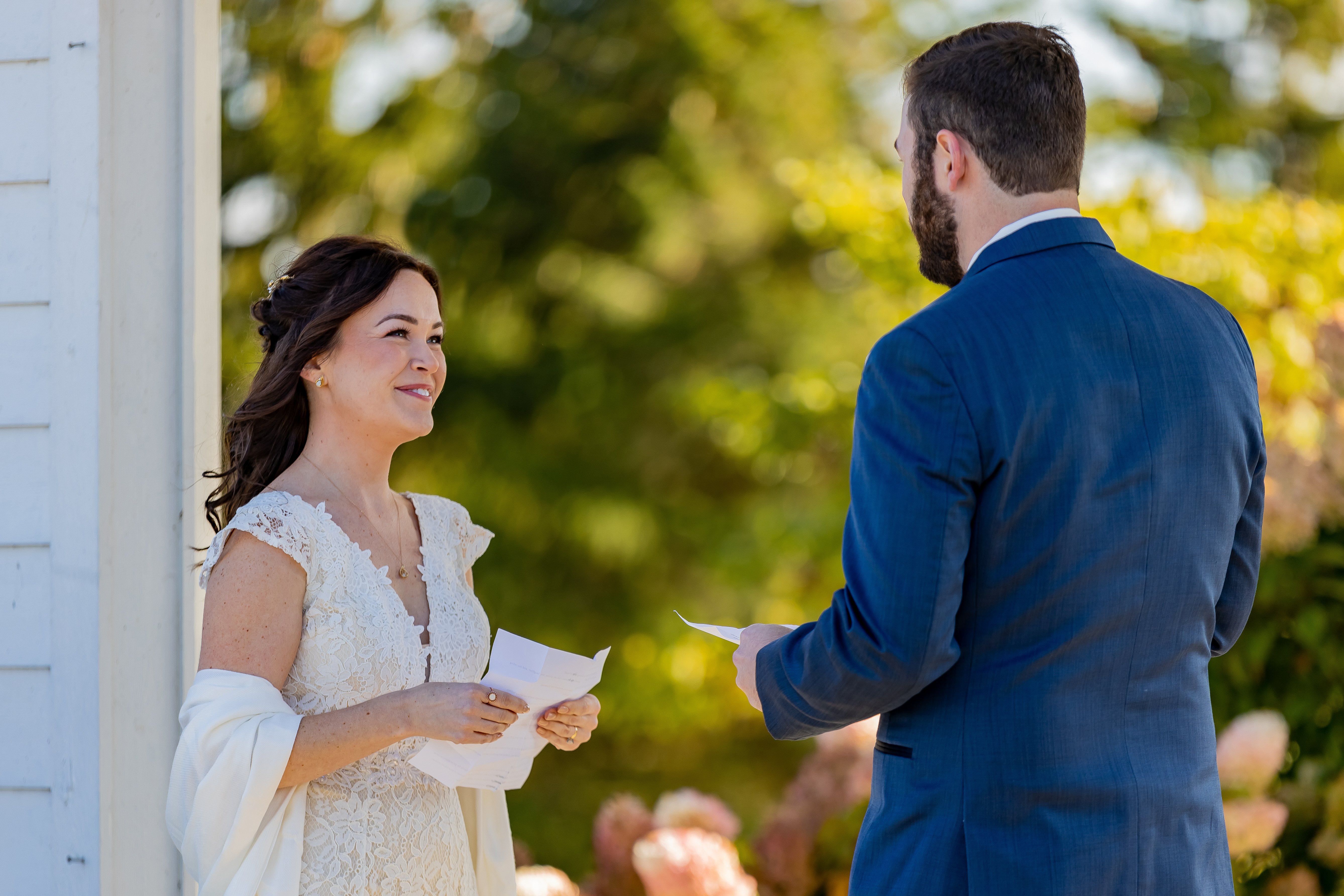 bride and groom reading vows to each other