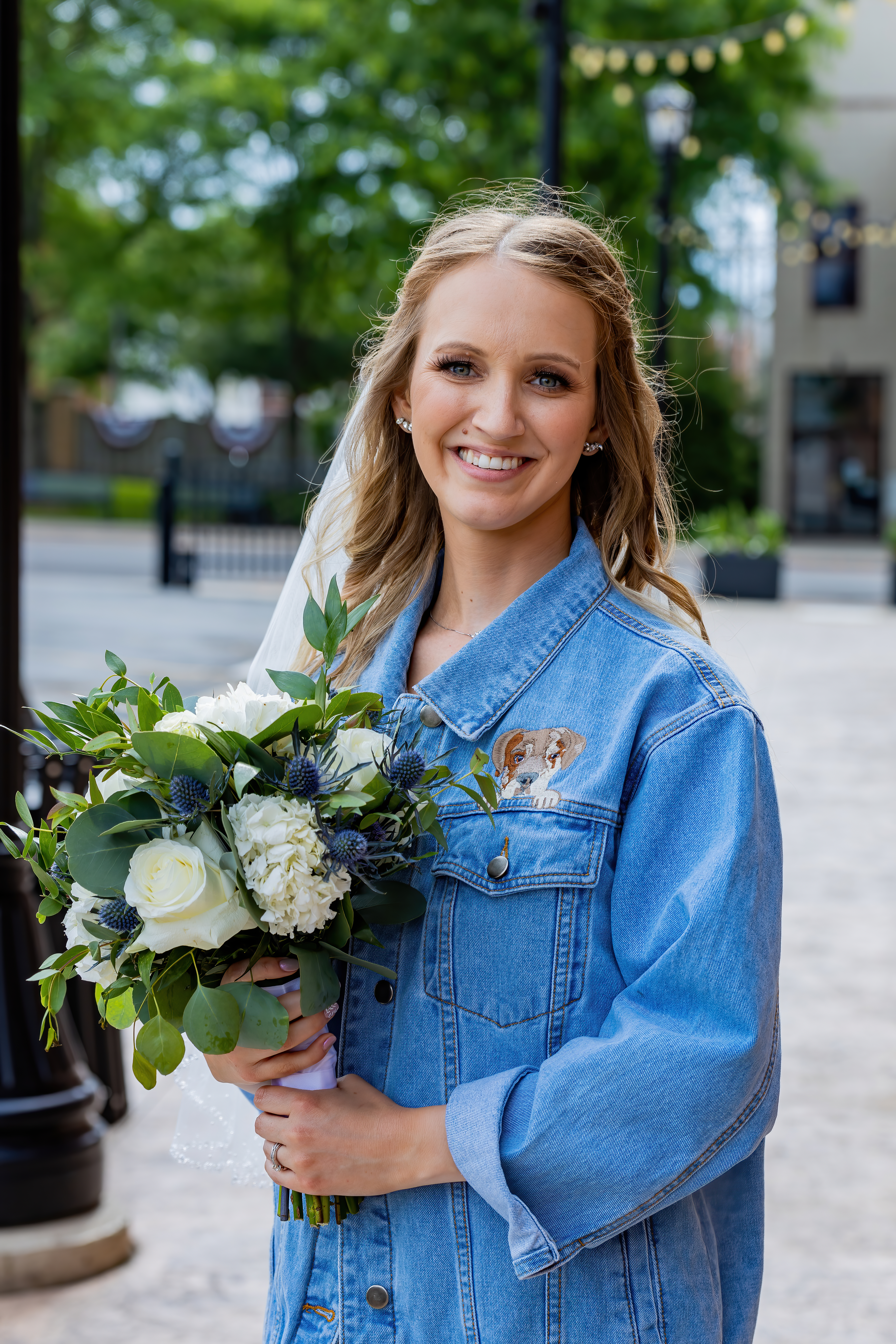 bride in denim shirt holding bridal bouquet