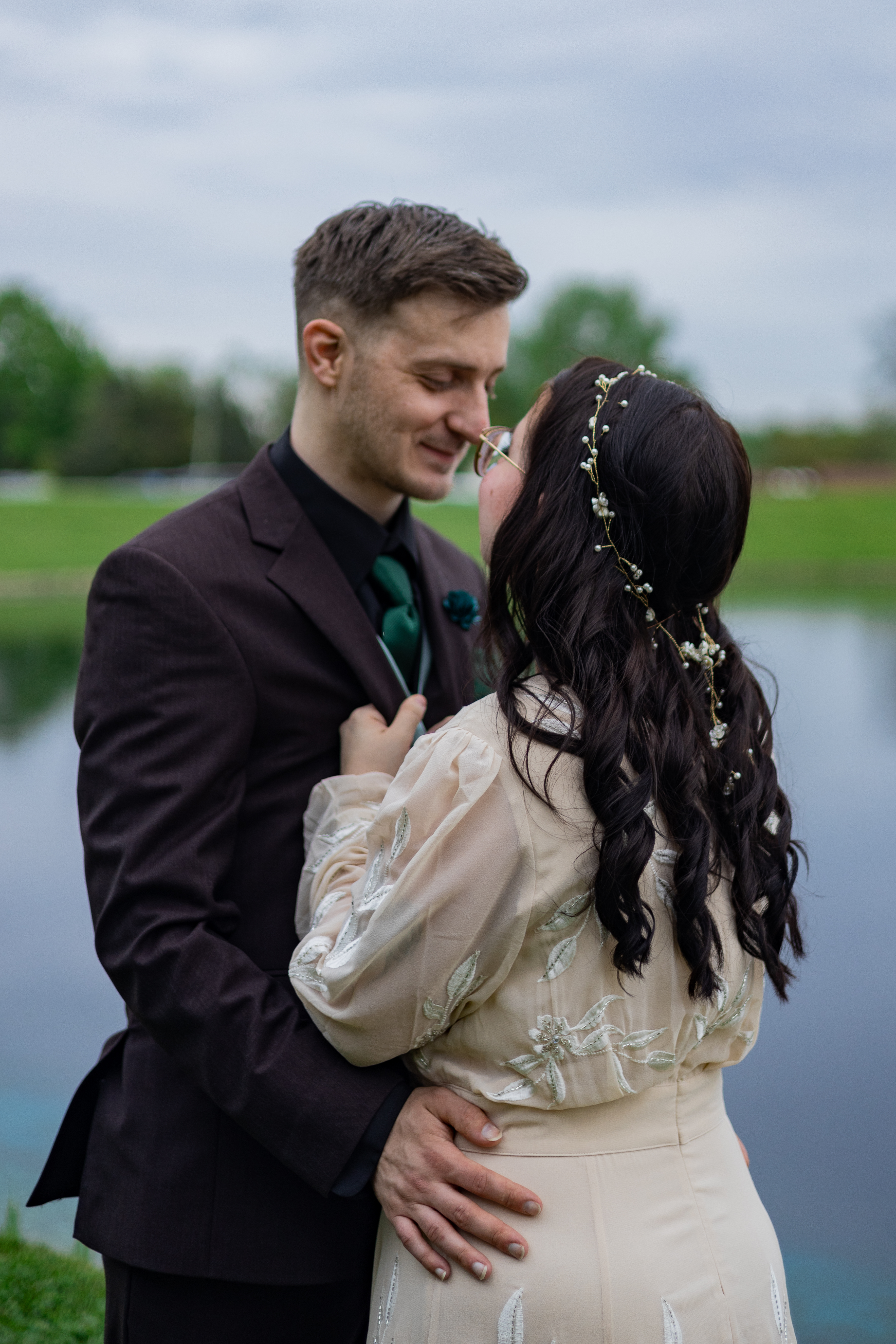 bride and groom embracing by lake