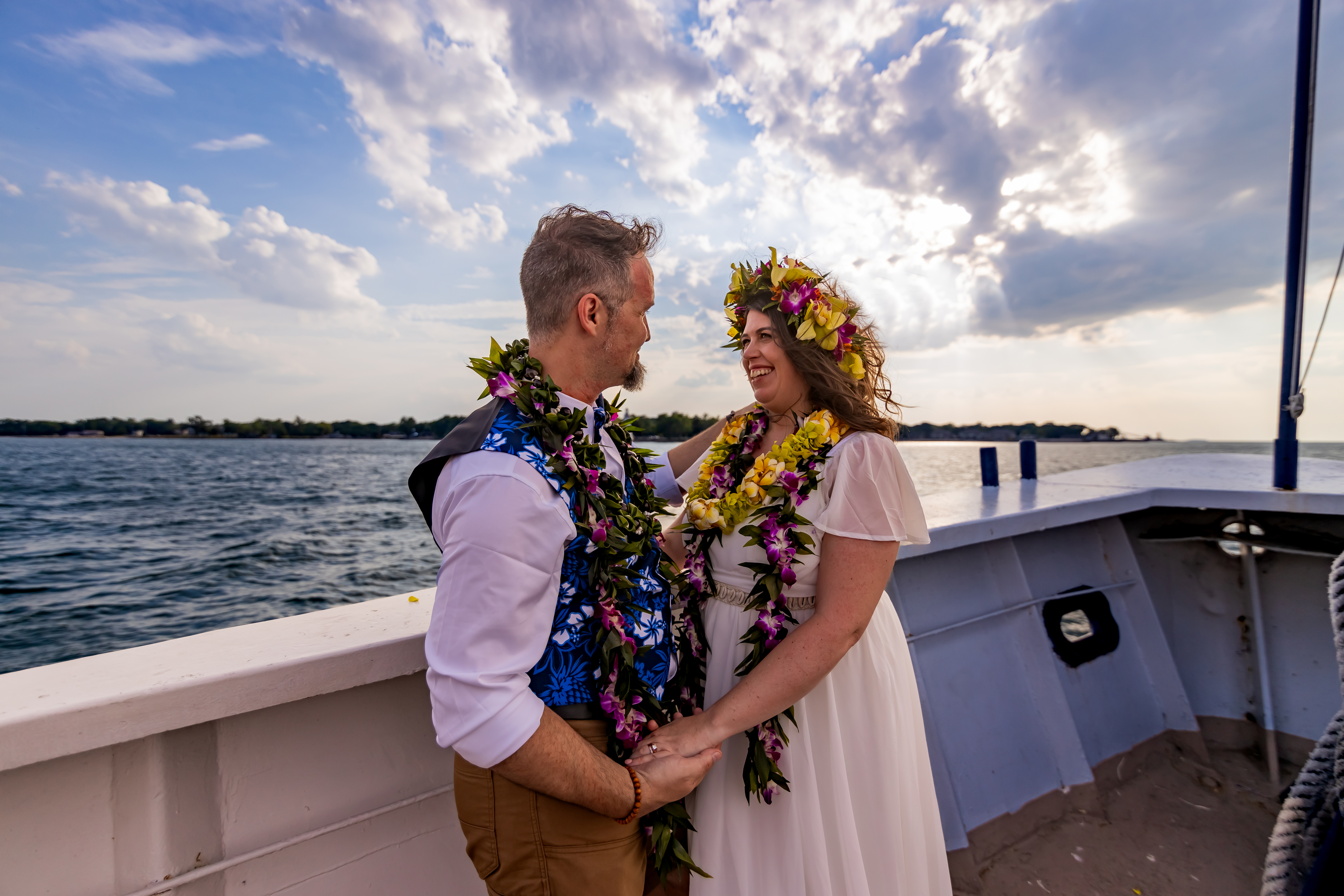 bride and groom on boat wearing leis