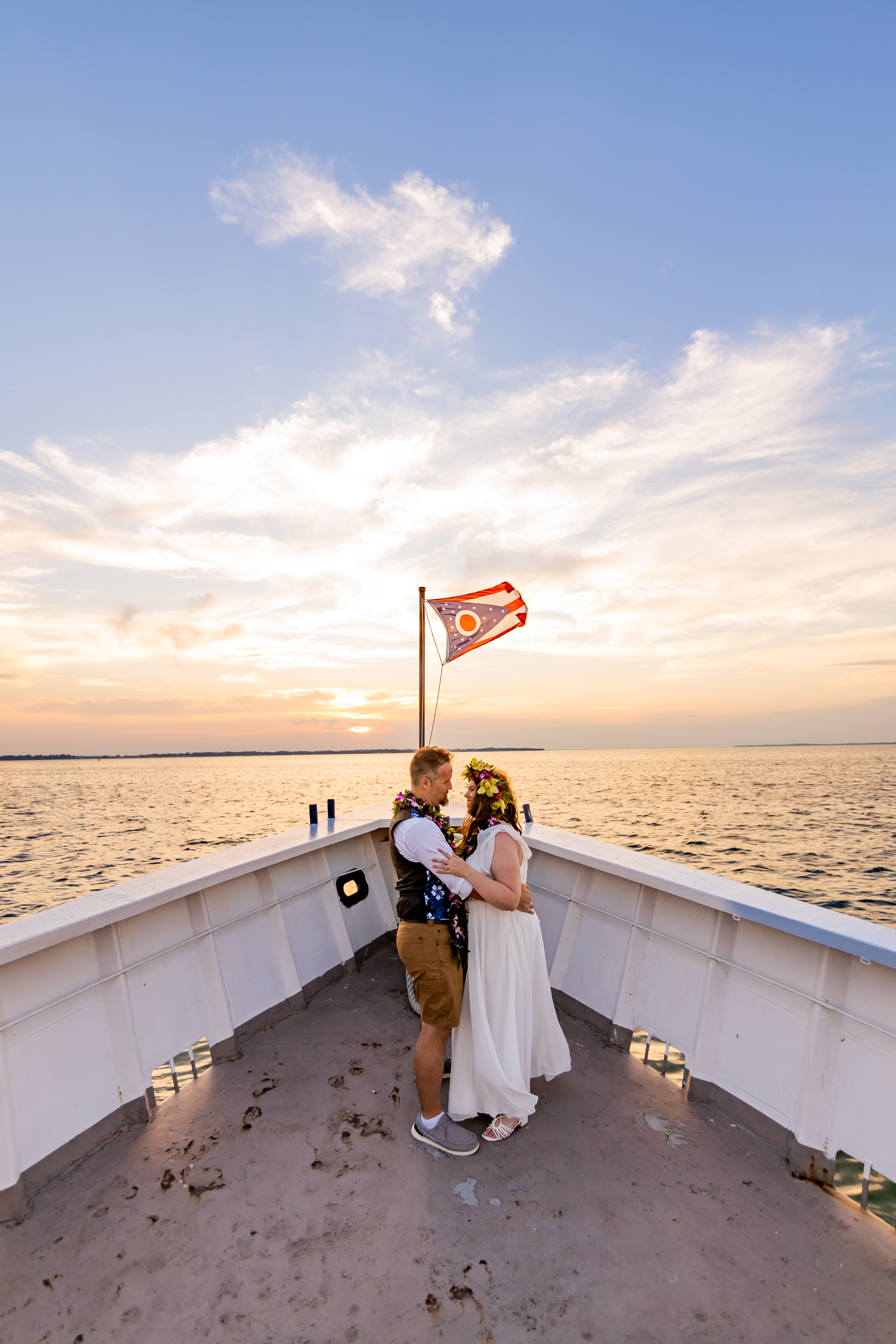 bride and groom on boat at sunset