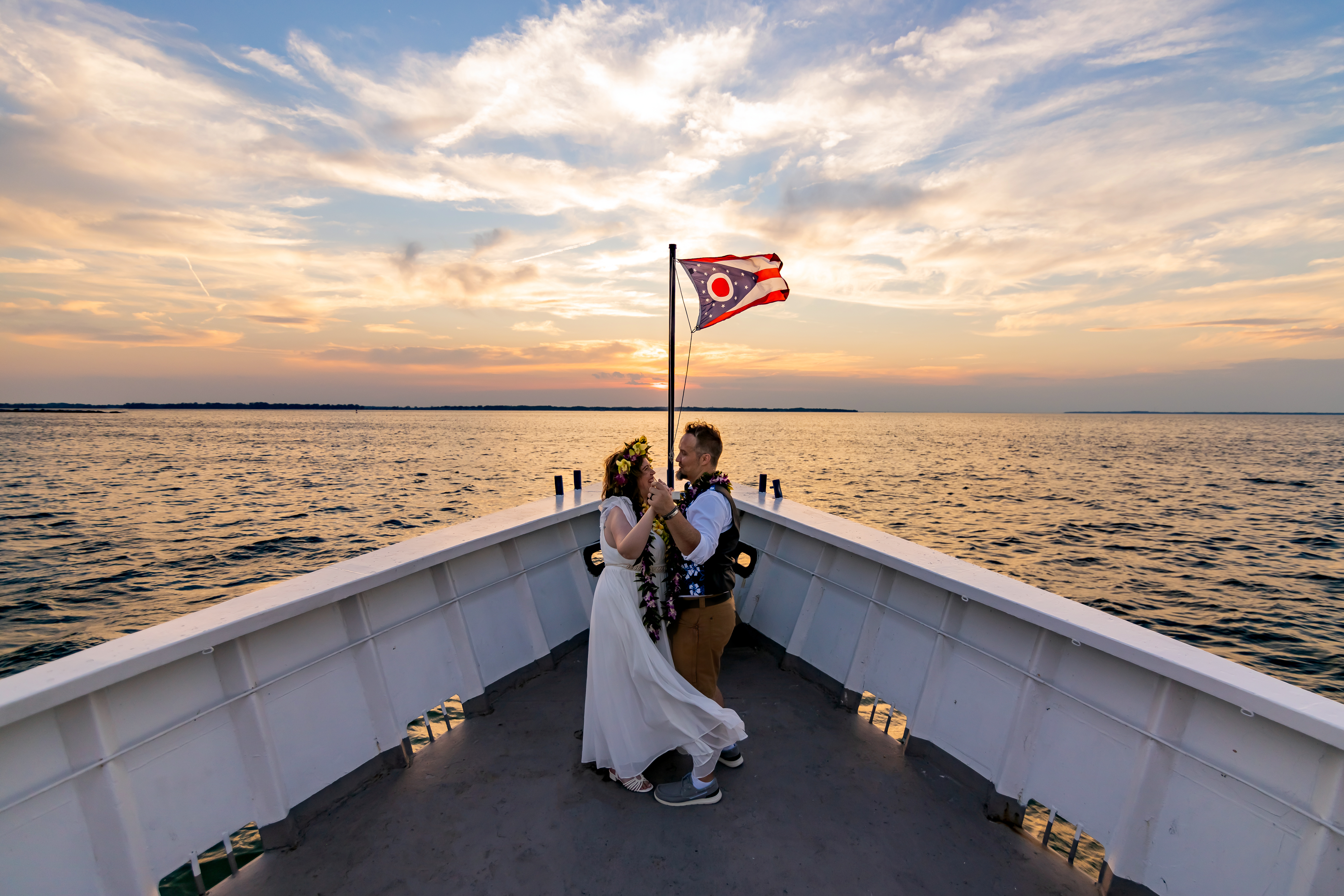 bride and groom's first dance on boat at sunset