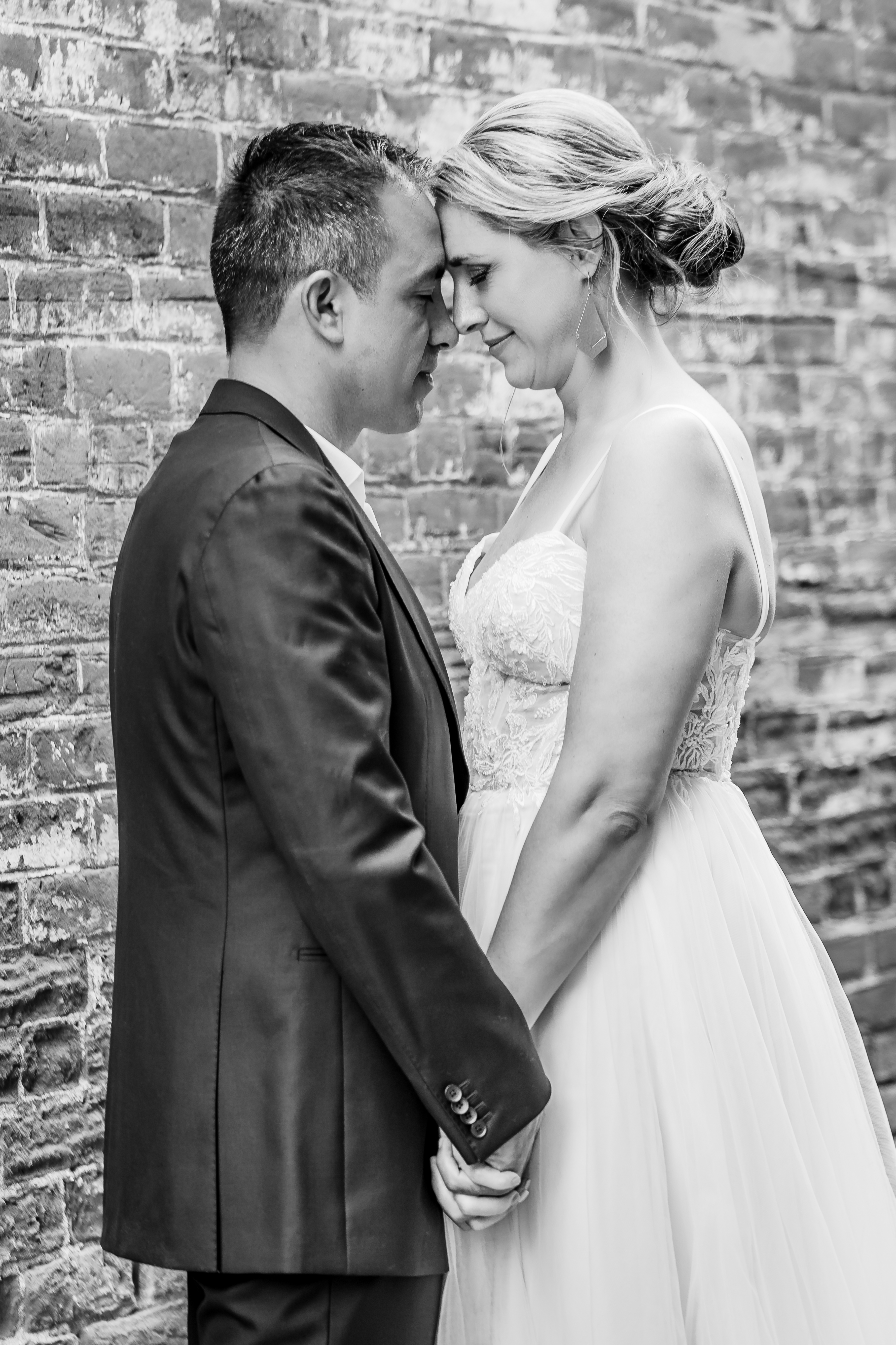 black and white wedding photo of bride and groom holding hands