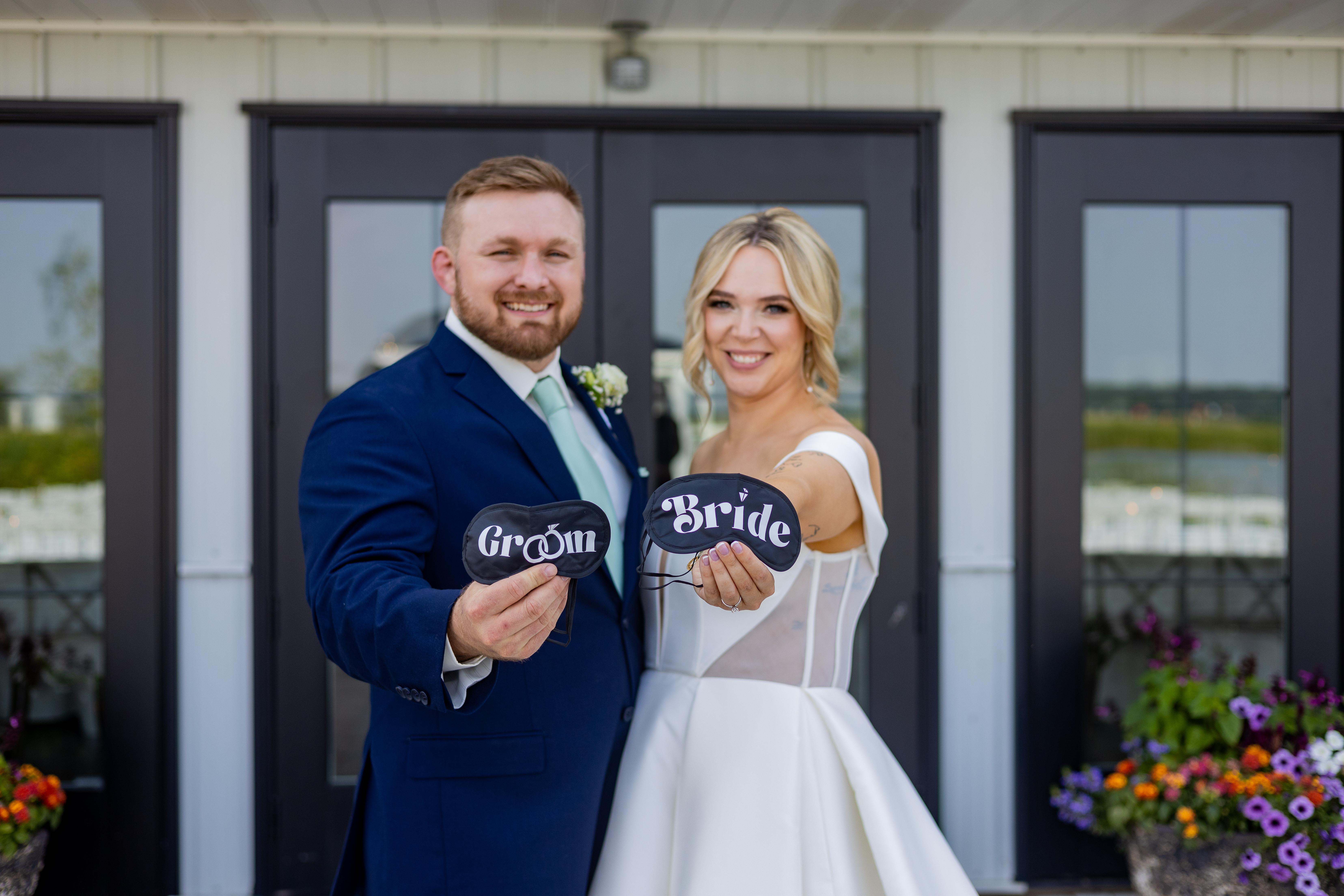 couple holding bride and groom eye masks