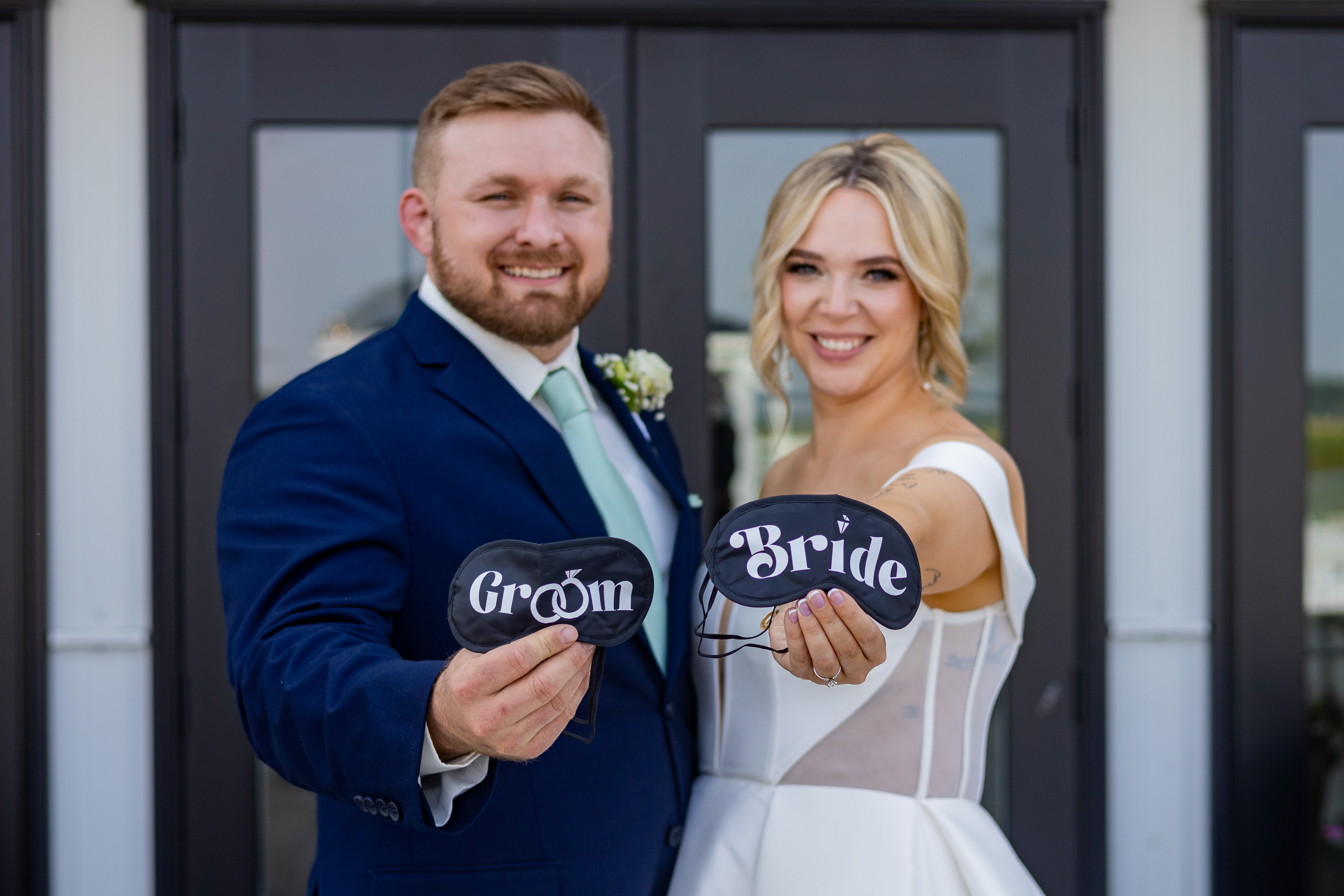 bride and groom holding eye masks