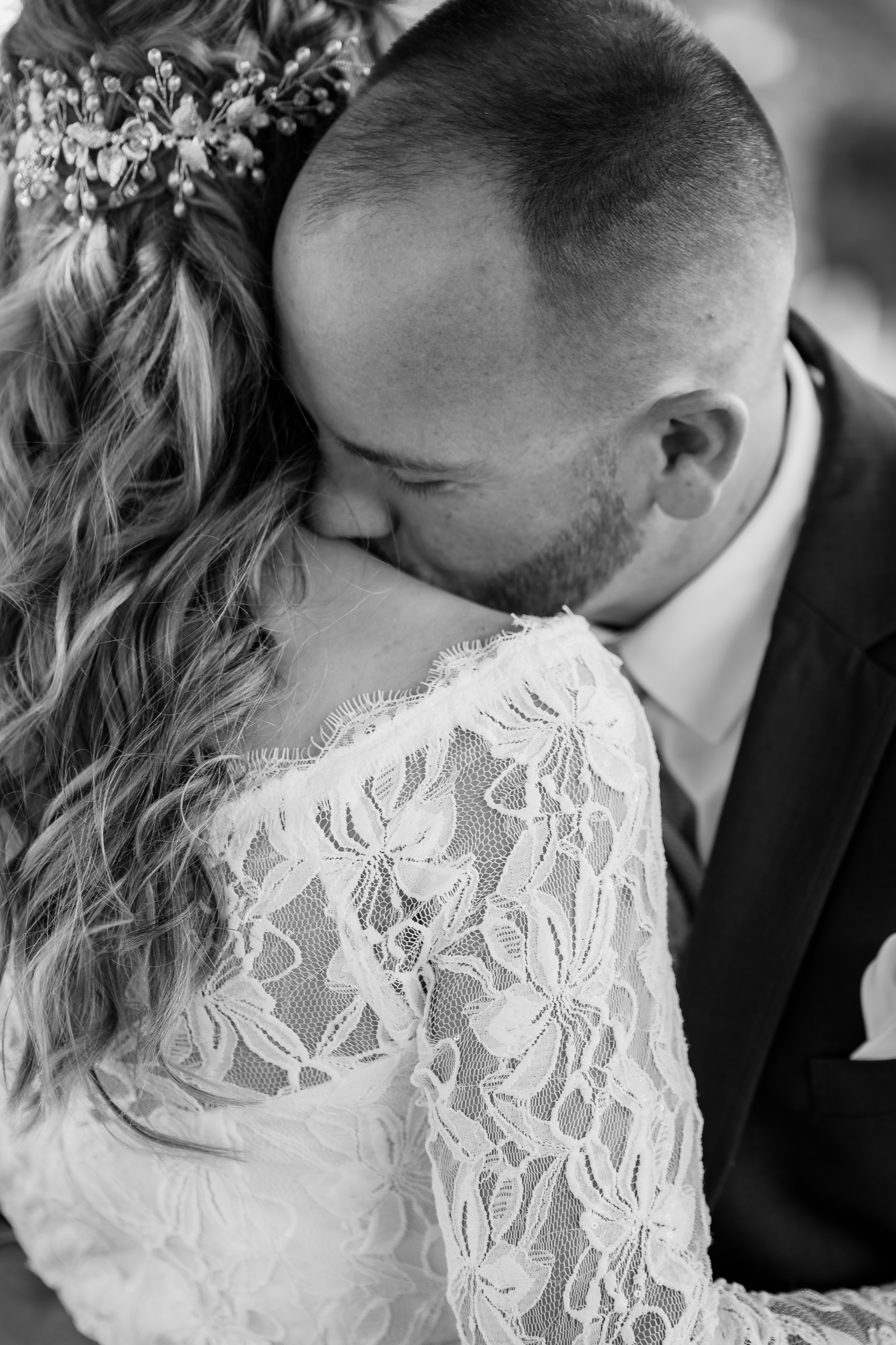 black and white portrait of bride and groom embracing