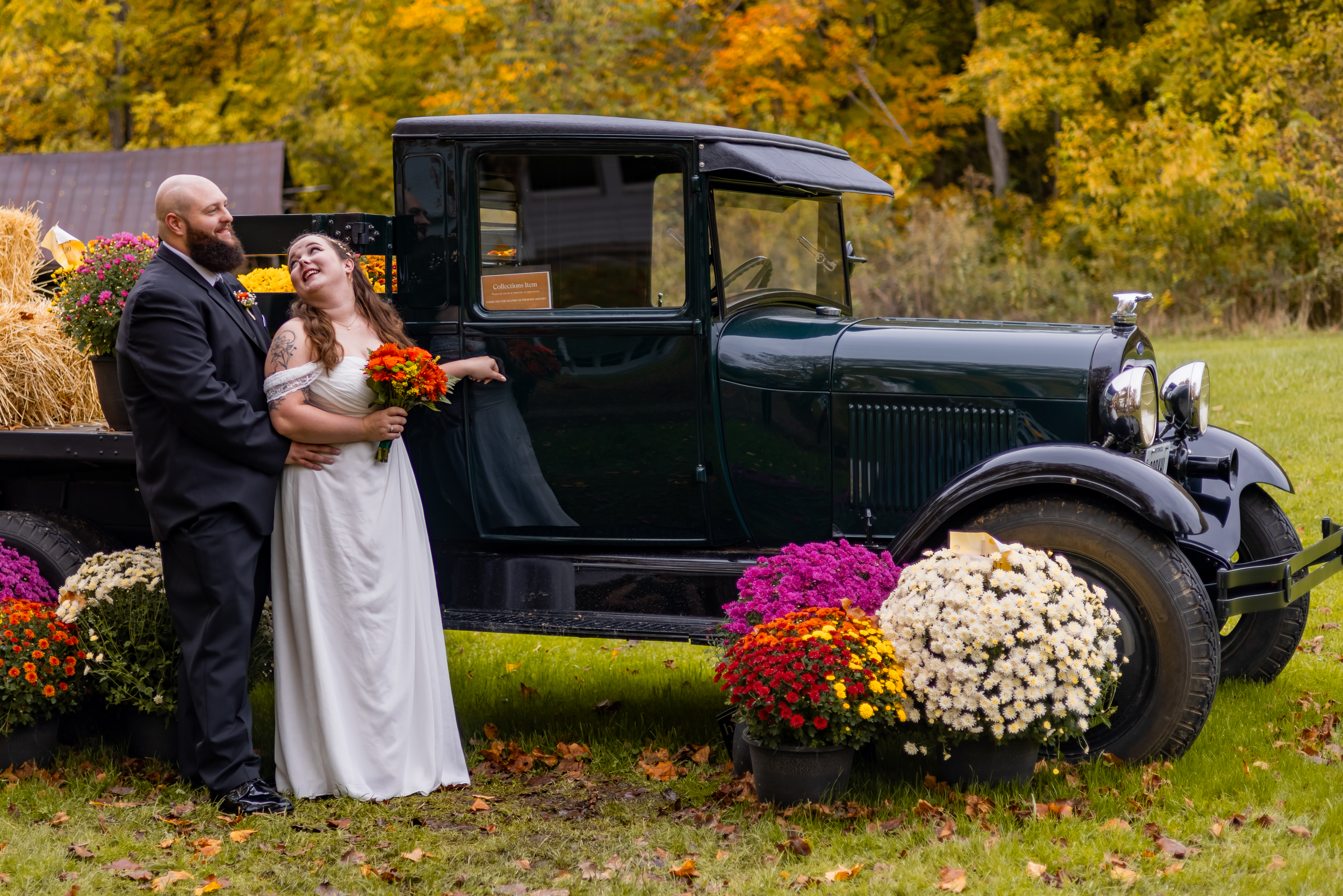 bride and groom posing with antique truck