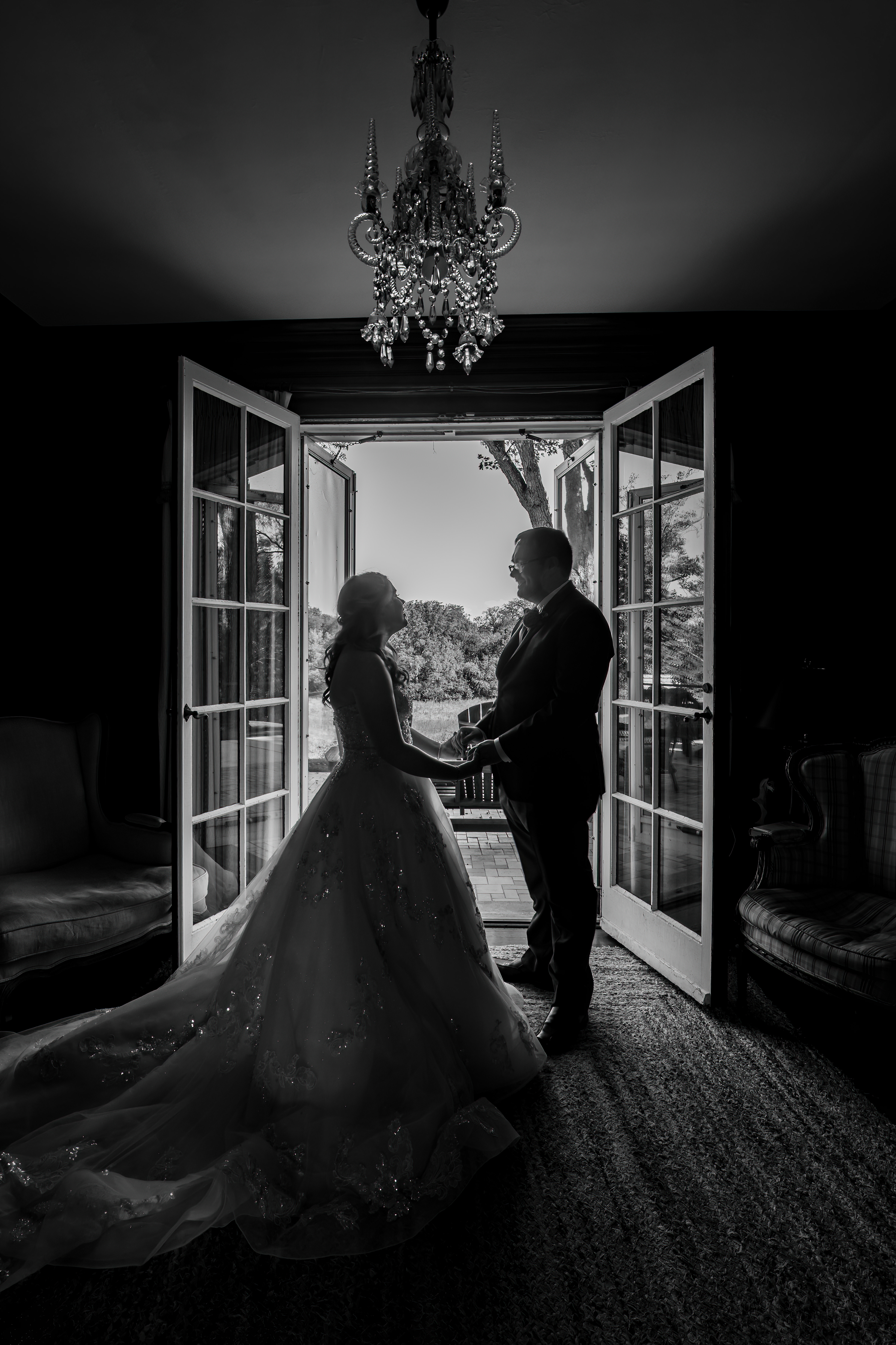 black and white portrait of couple standing in open doorway