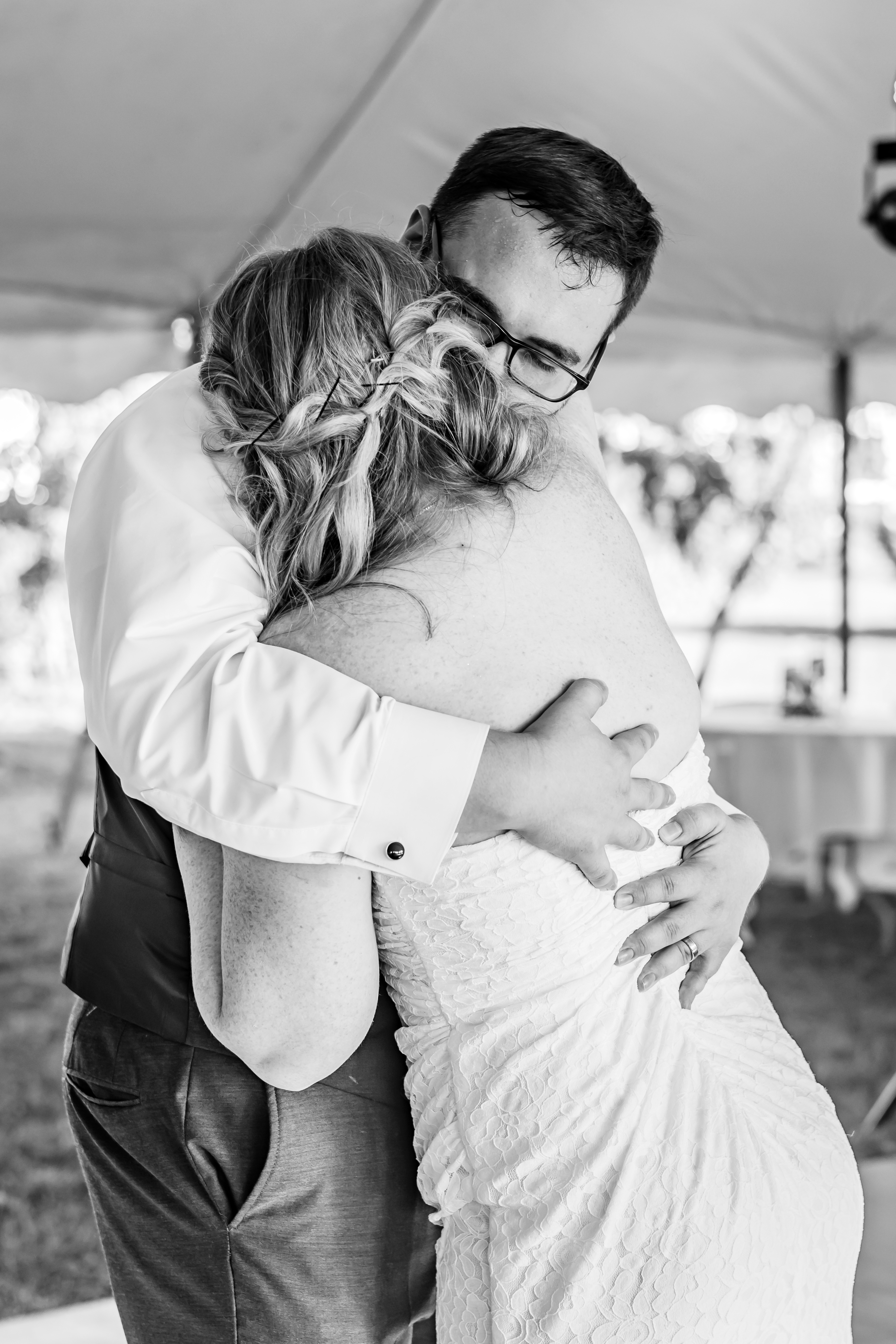 black and white portrait of bride and groom hugging
