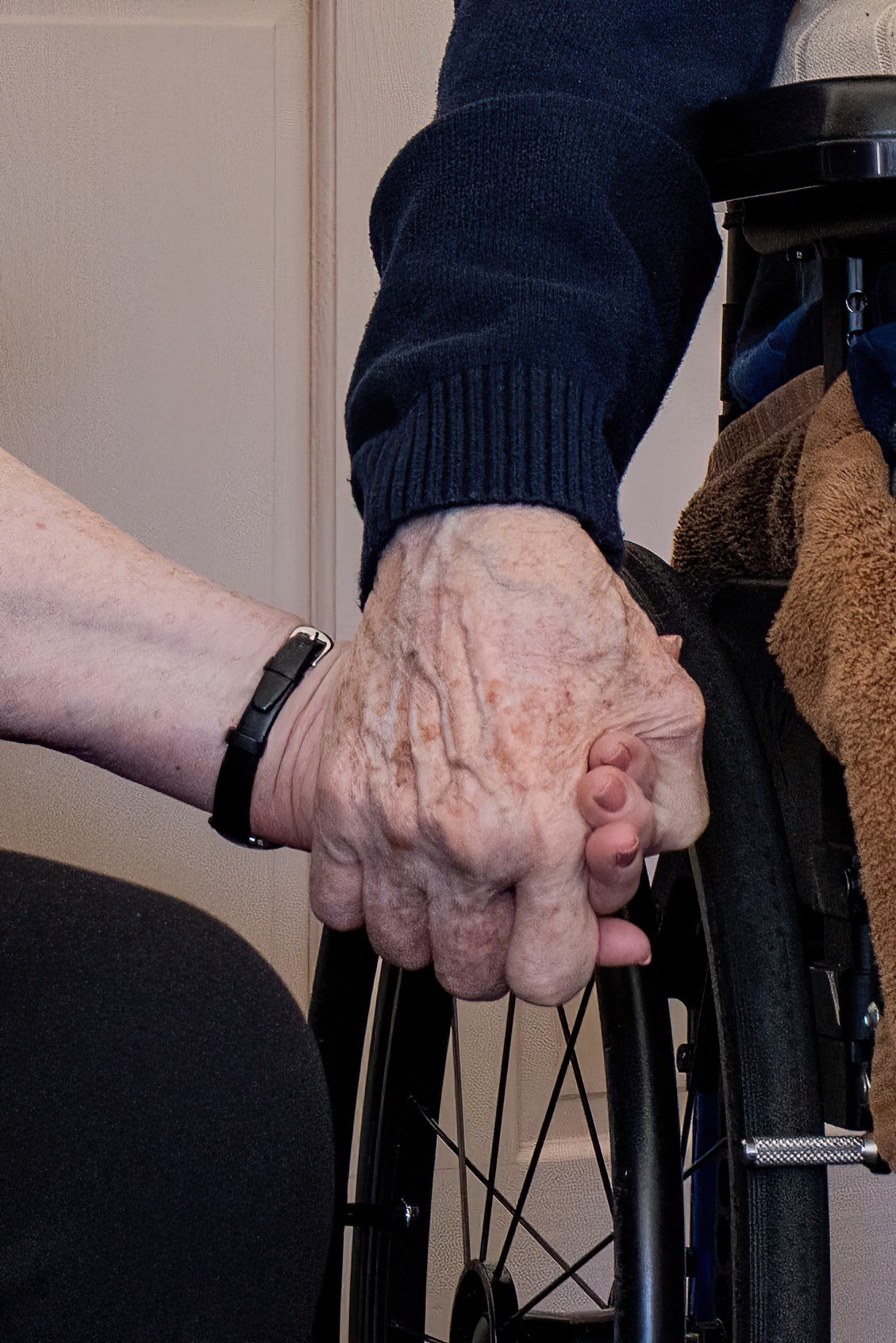 elderly couple holding hands