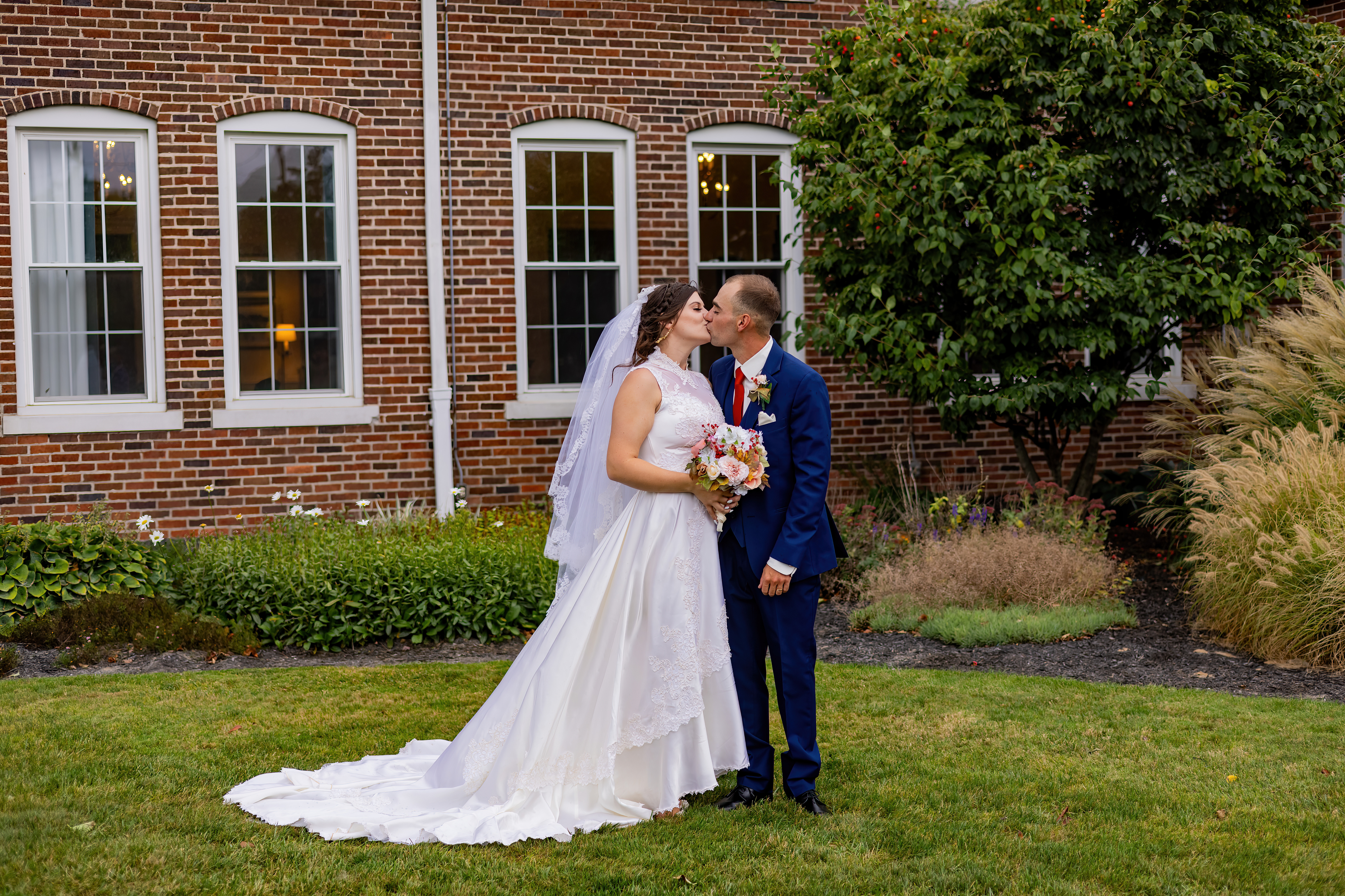 bride and groom kissing outside venue