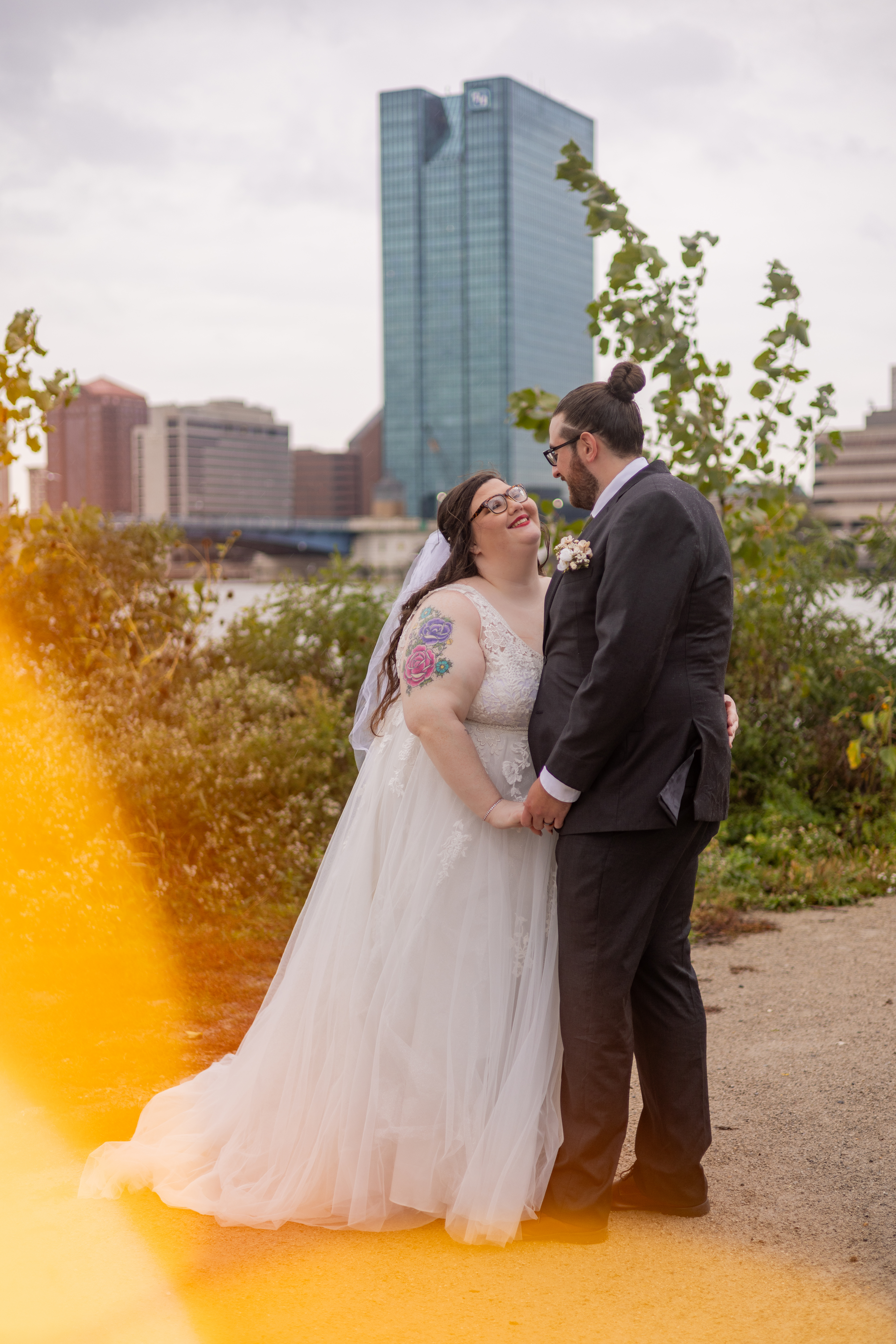 bride and groom embracing with skyline in background