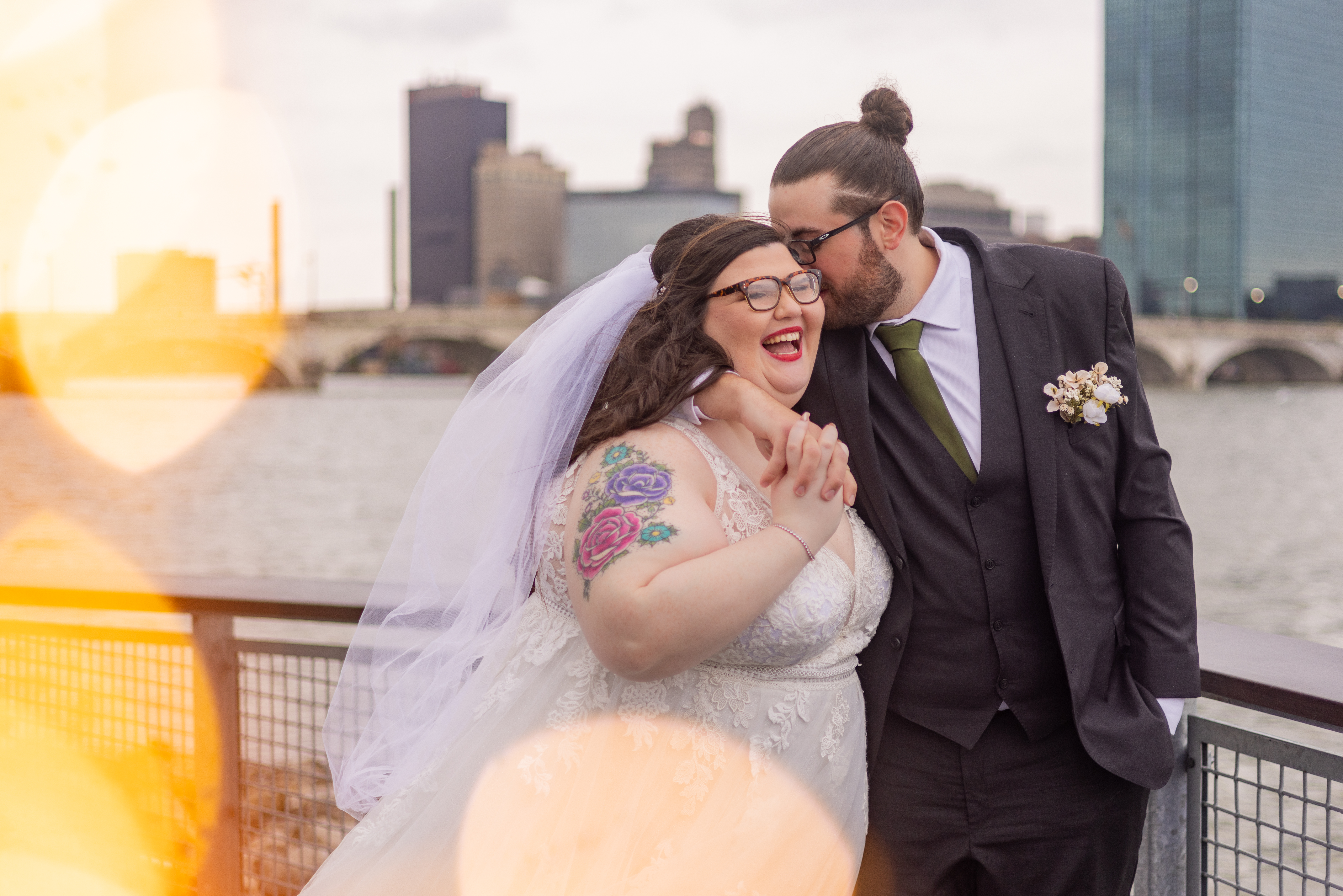 groom embracing bride while she laughs