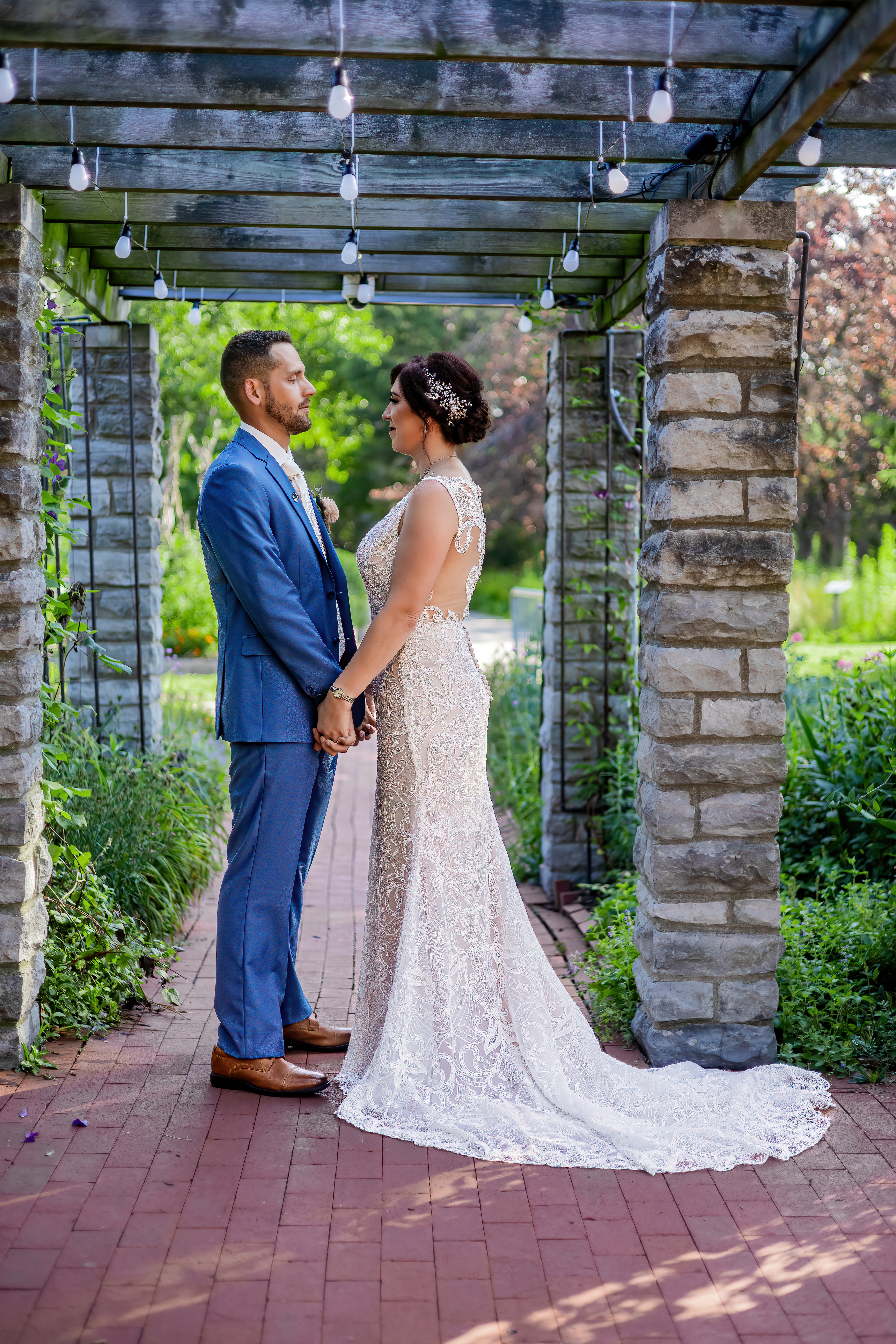 bride and groom holding hands under pergola