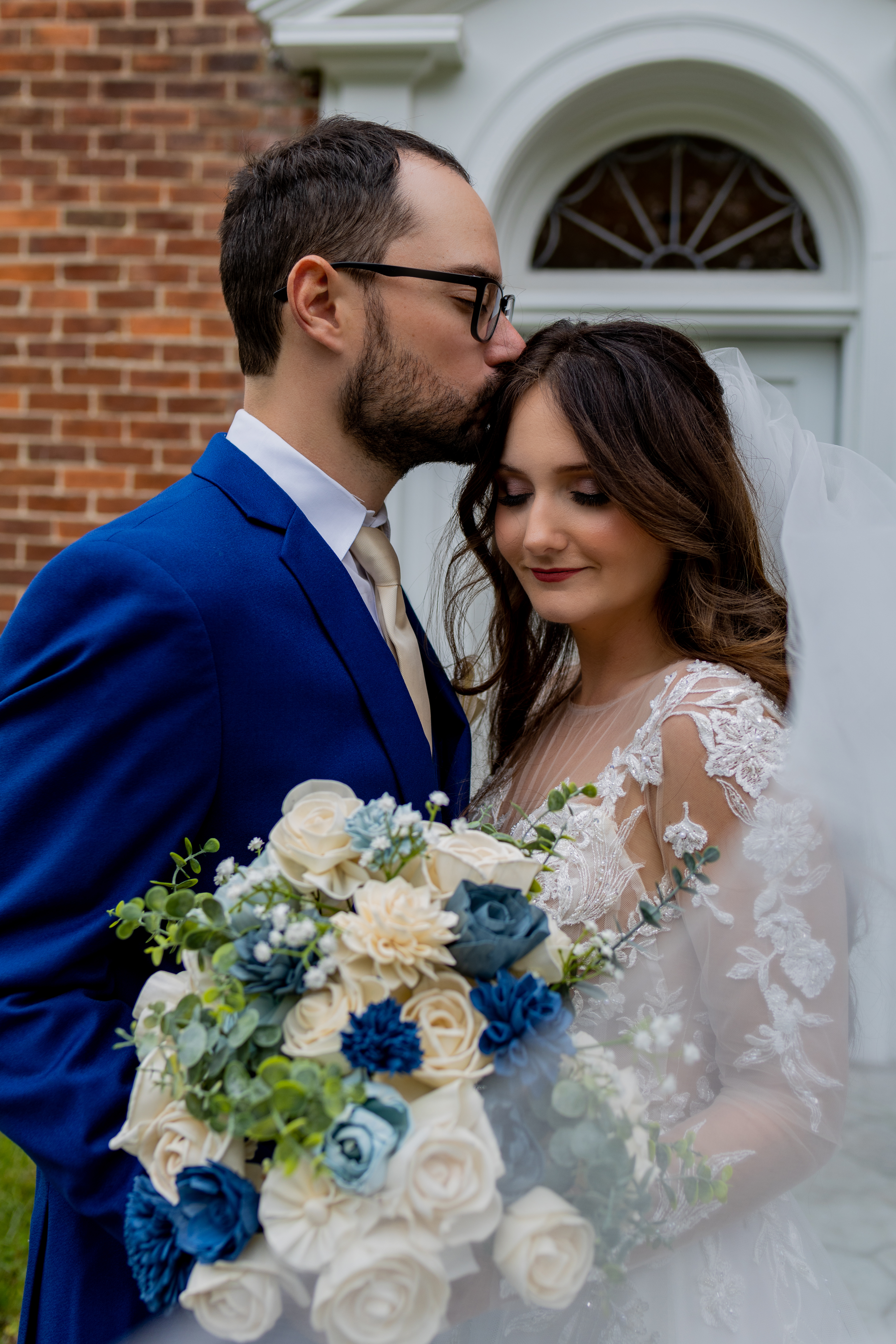 groom kissing bride on forehead