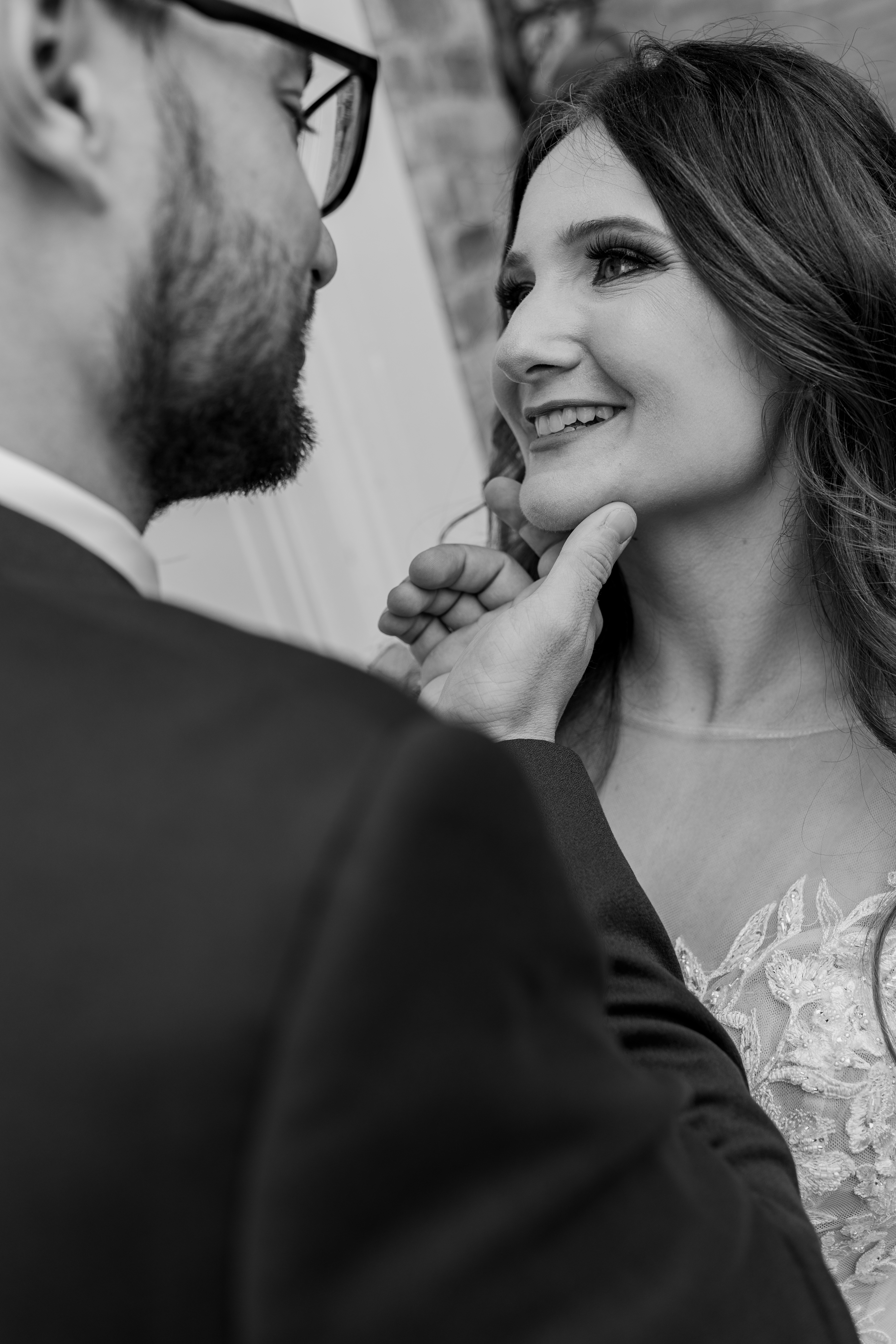 black and white portrait of bride and groom looking at each other lovingly