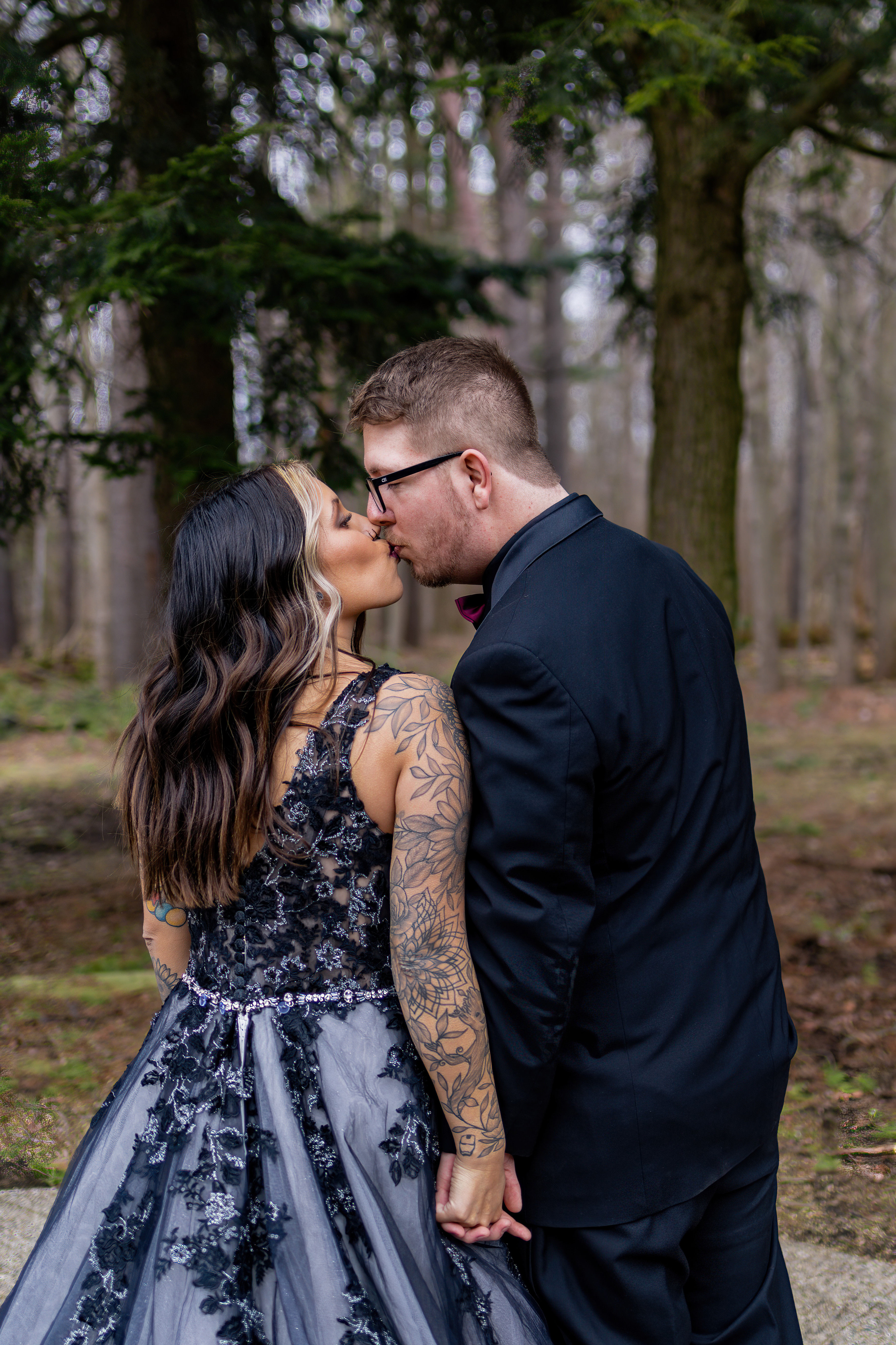 bride in black lace gown kissing groom