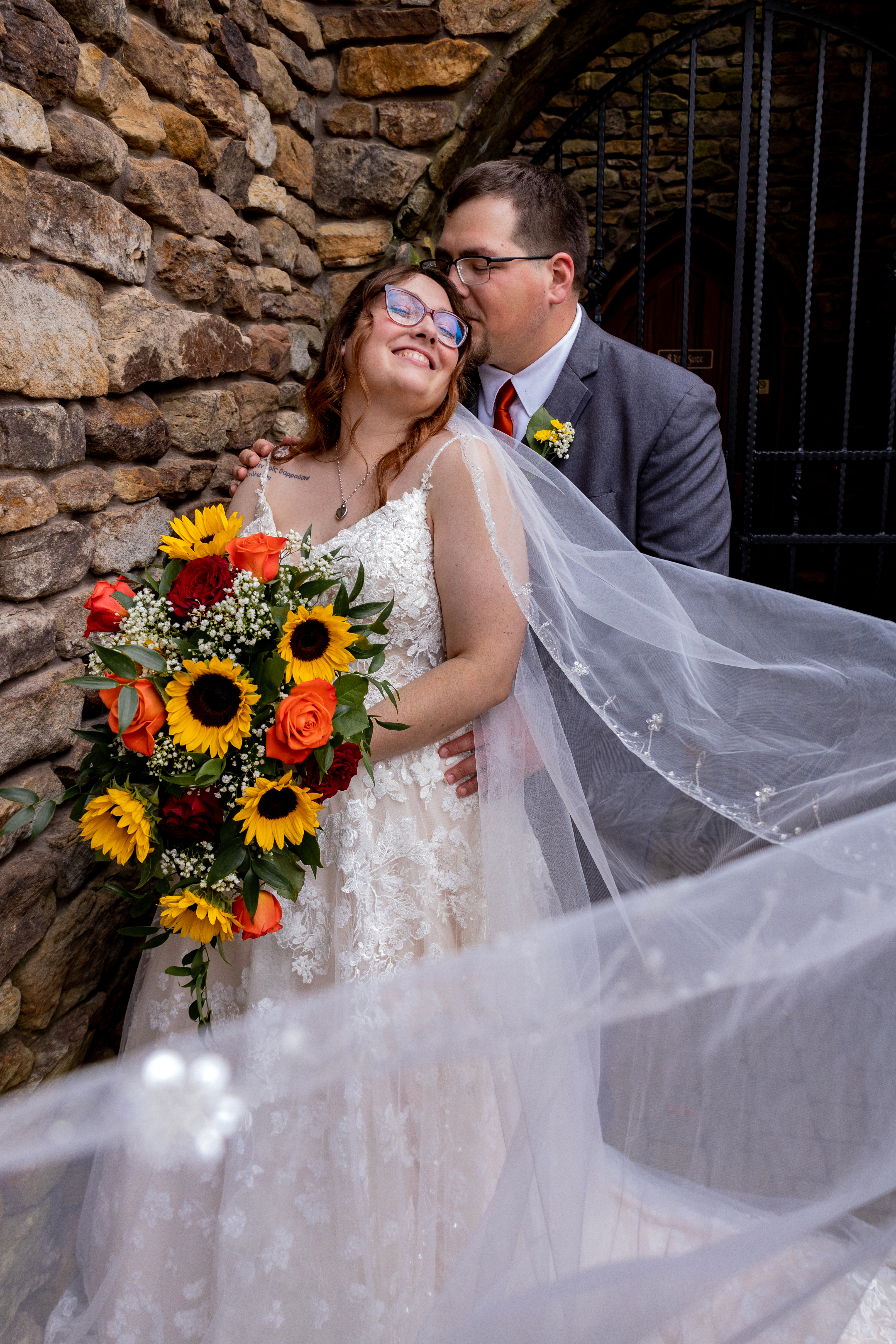 groom kissing bride surrounded by veil