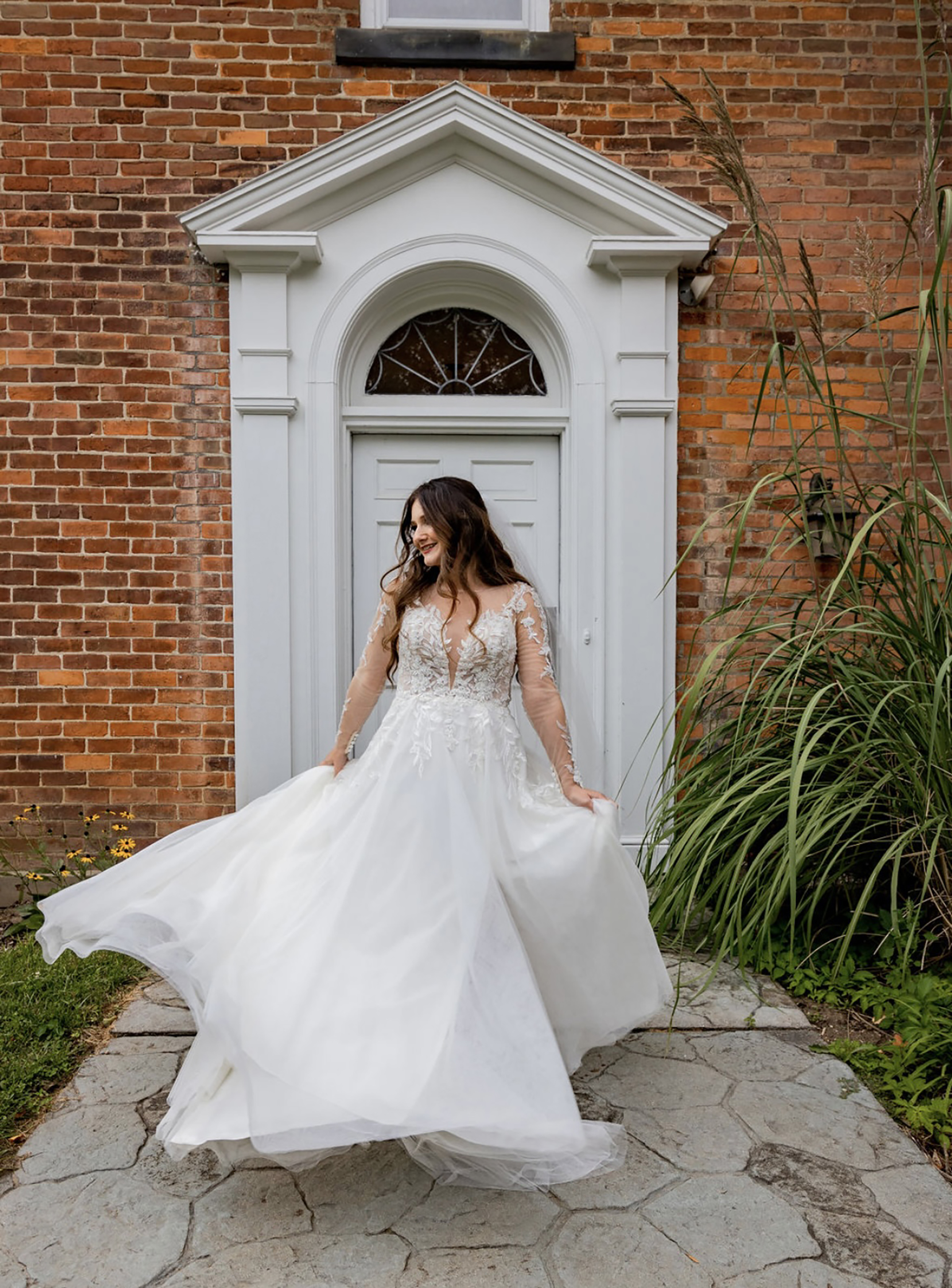 bride twirling gown in front of venue
