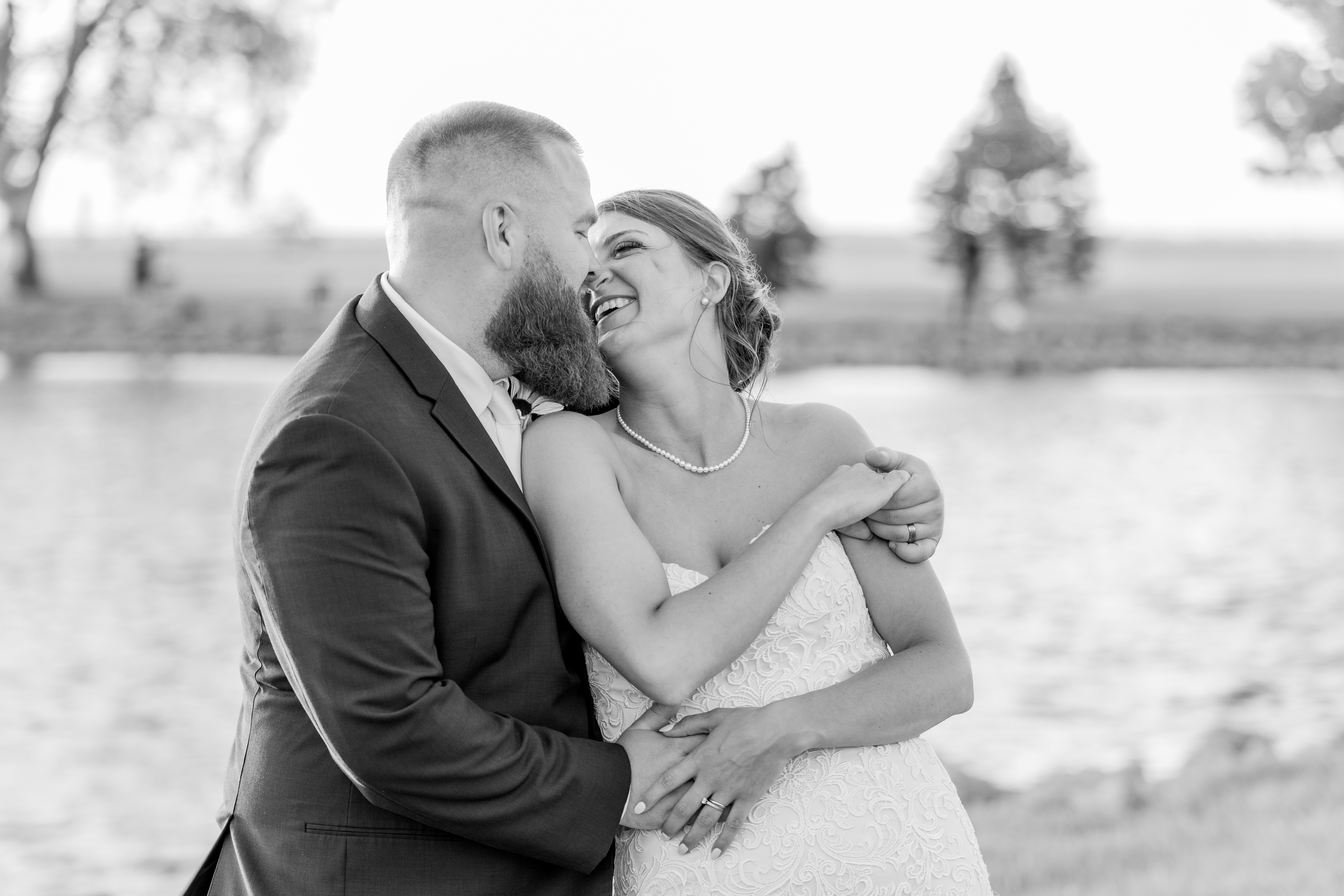 black and white portrait of bride and groom laughing and embracing