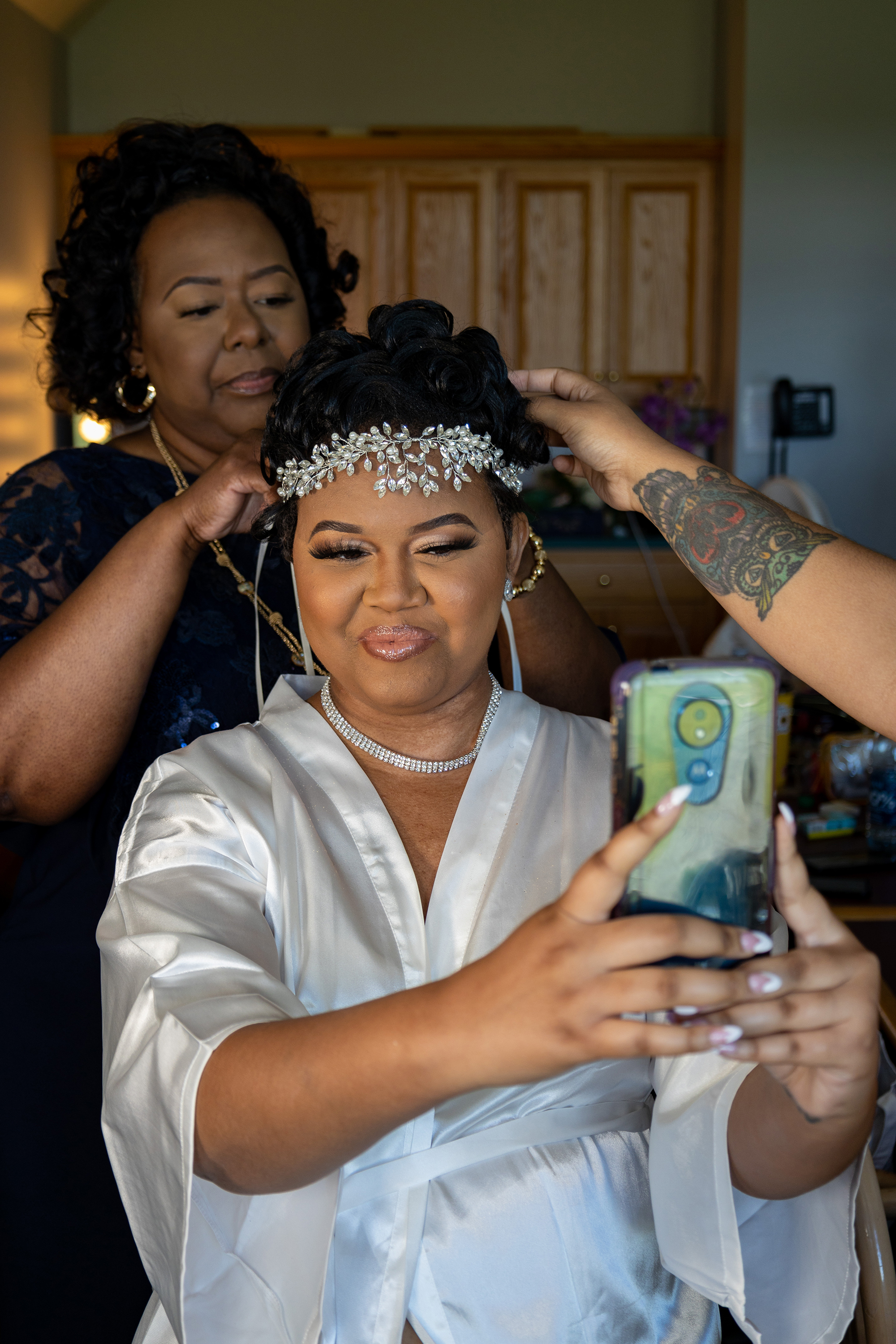 bride taking cute selfie while her mom fixes her hair