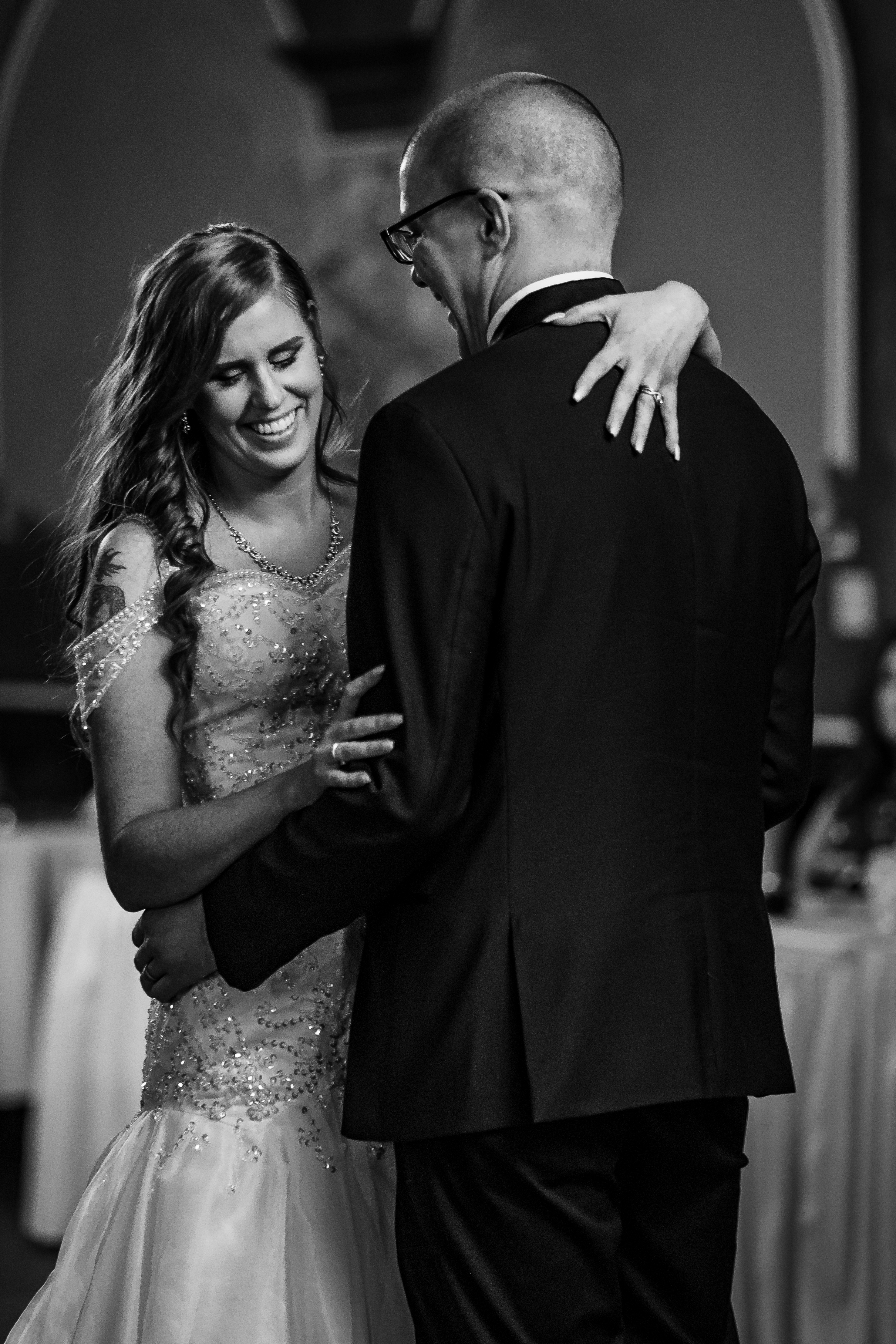 black and white portrait of bride and groom smiling at each other